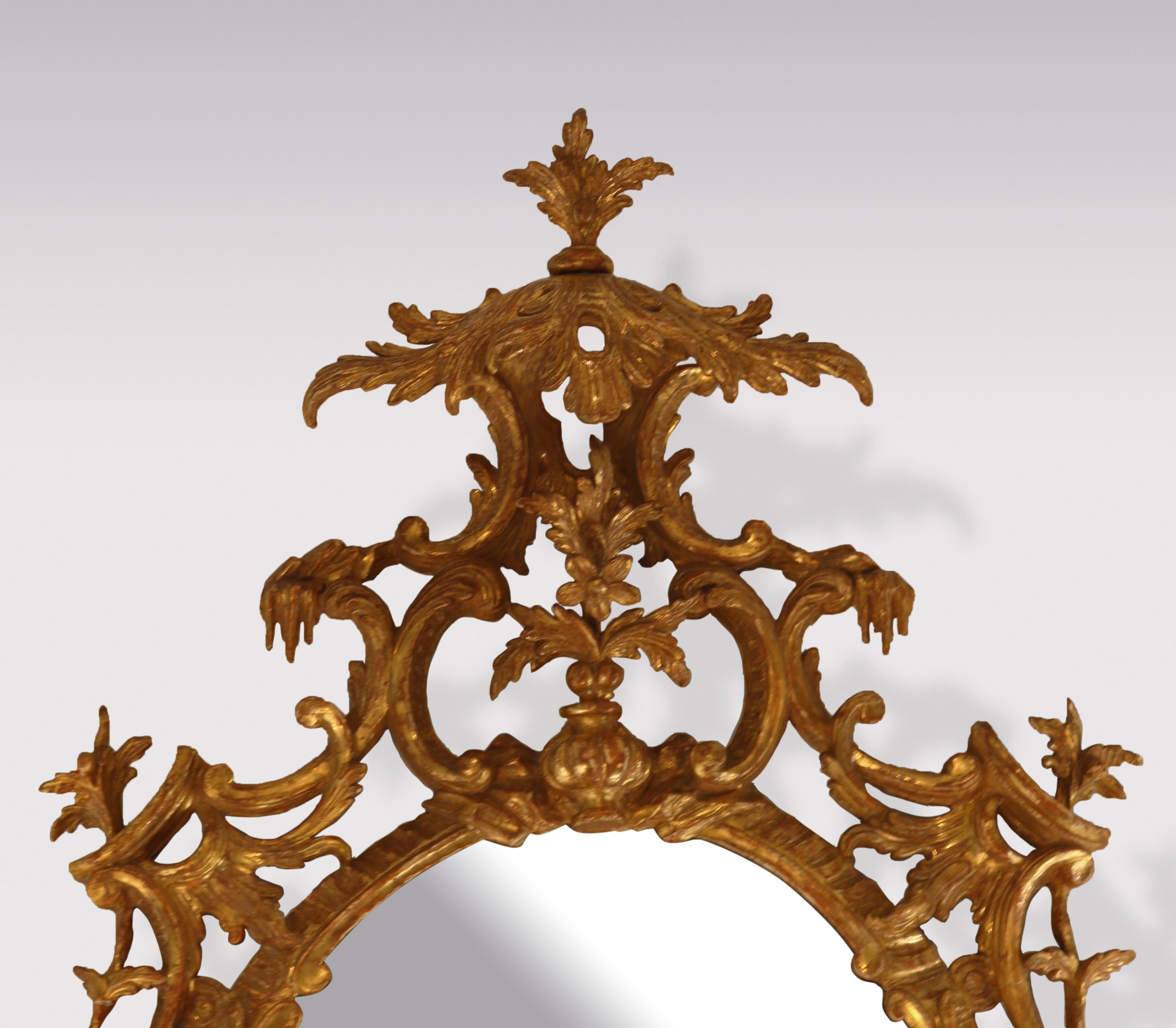 Miroir ovale en bois doré sculpté de la période Chippendale, de belle qualité, datant du milieu du XVIIIe siècle, avec un cartouche à baldaquin en forme de feuille au-dessus d'un vase avec des fleurs. Le miroir est orné d'une fleur et d'une acanthe
