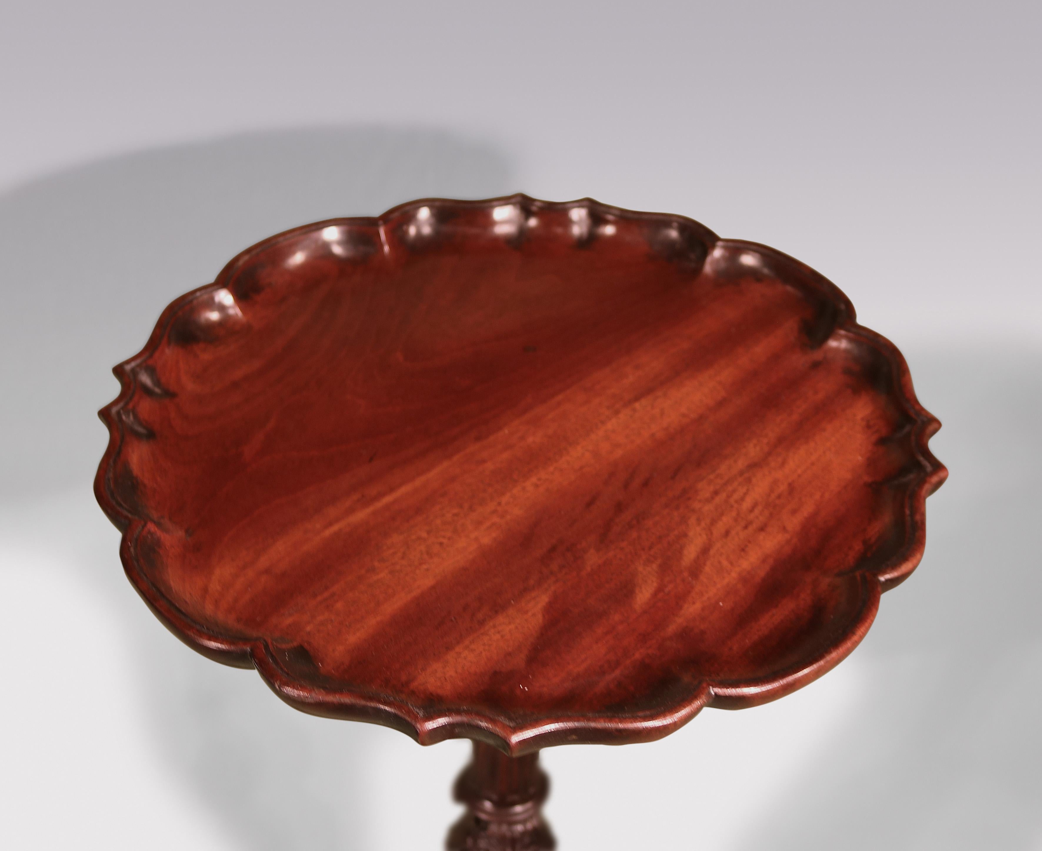 A fine mid-18th Century Chippendale period figured mahogany Kettle Stand, having scalloped piecrust edged top above stop-fluted stem with acanthus carved knop & gadrooned carved vase raised on well-carved tripod base ending on claw & ball feet.