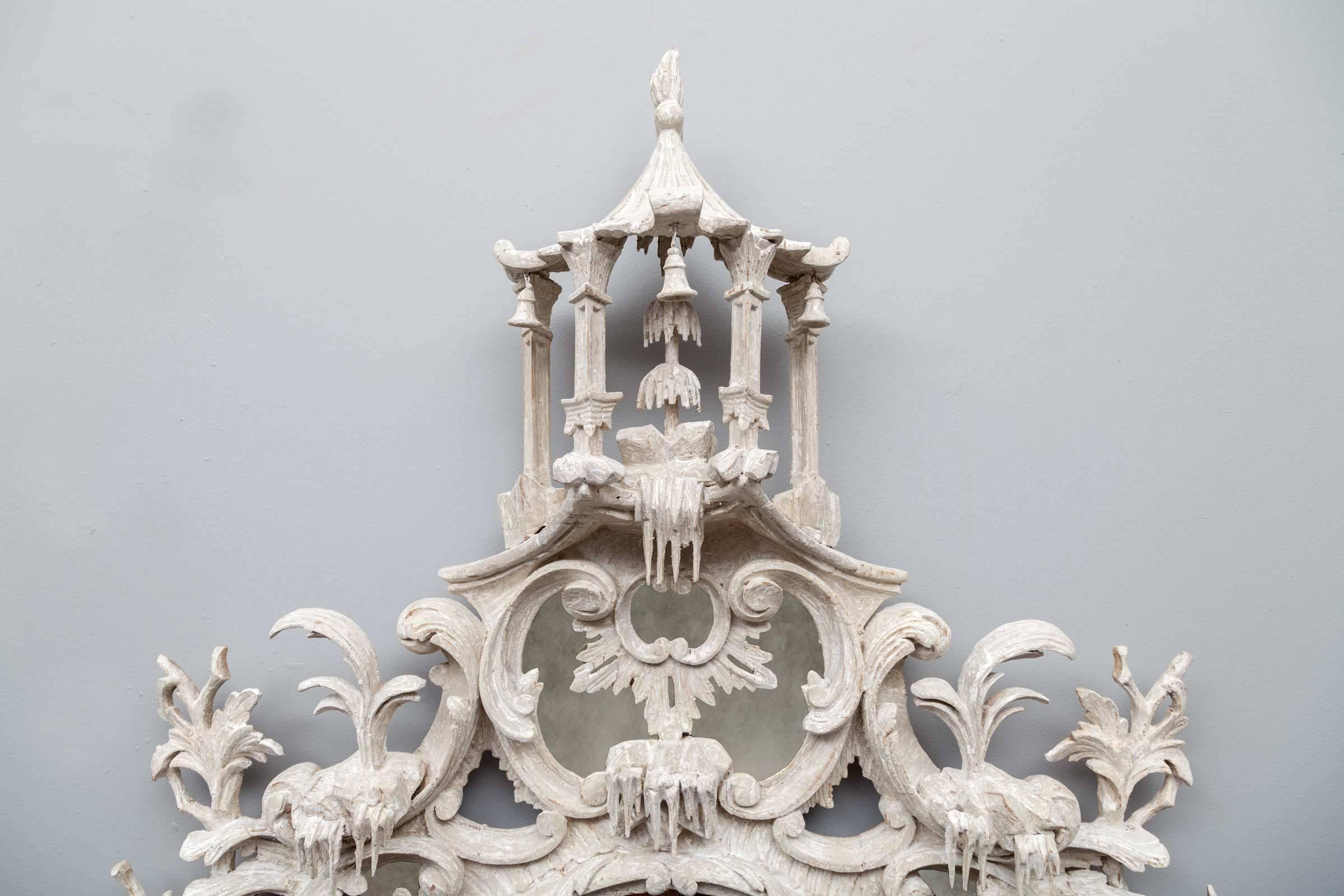 Un très beau miroir en bois sculpté et peint du milieu du XVIIIe siècle, de la période Chippendale. Le cadre en bois peint, exceptionnellement bien sculpté, entoure un miroir central ovale avec des miroirs de bordure en forme en haut et en bas.