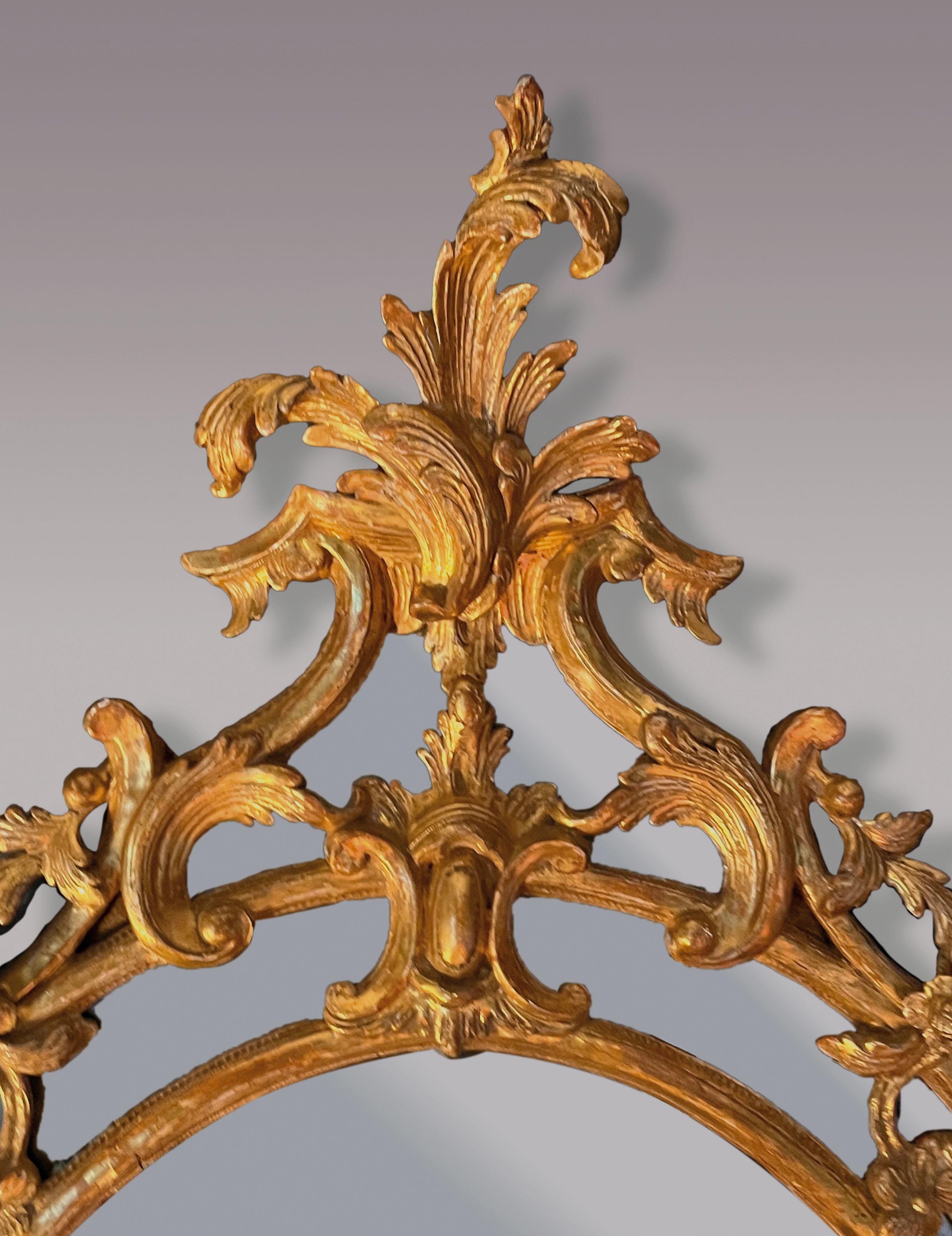 Espejo rococó ovalado de madera dorada tallada de mediados del siglo XVIII, de la época de Chippendale, con cartela de hojas y volutas florales y marco tallado con acanto y detalles de frutas y flores.  Los bordes del marco tienen fondo de espejo,