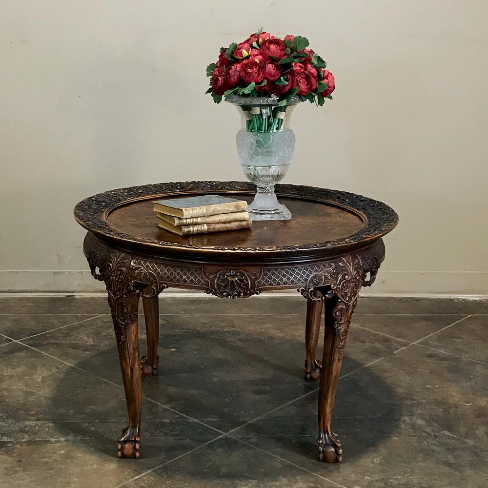 Antique Chippendale round end table is the ideal companion for any seating group, and features the signature talon and ball feet on gracefully scrolled legs. Exquisite burl wood with intricate foliate relief surrounding the burl like a framework