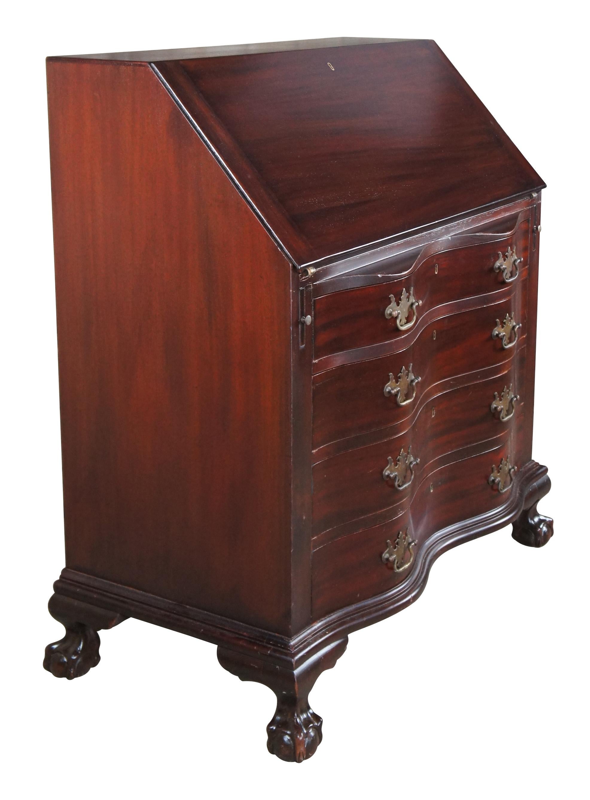 Antique early 20th century Chippendale style secretary or writing desk. Made of mahogany featuring serpentine form with drop front writing surface that opens to multiple drawers and cubbies, over four oxbow drawers that are mounted with classic