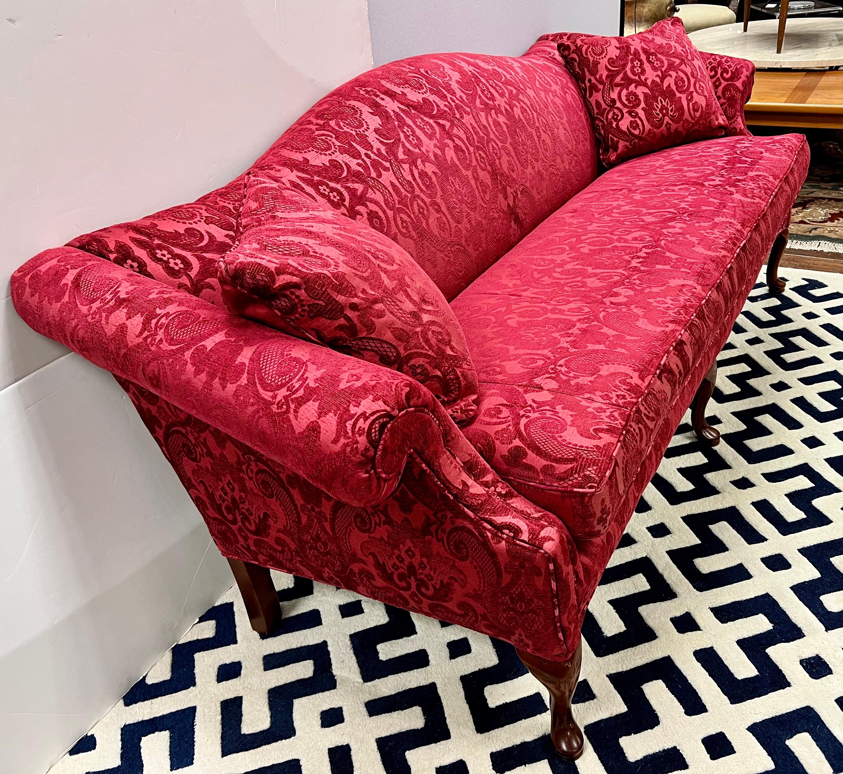 Magnificent chippendale style camelback antique sofa settee has scrolled arms and has been recently upholstered in a luxurious Fortuny embossed red velvet. Back of sofa is a coordinating solid red silk. Single seat cushion is down-filled. Comes with