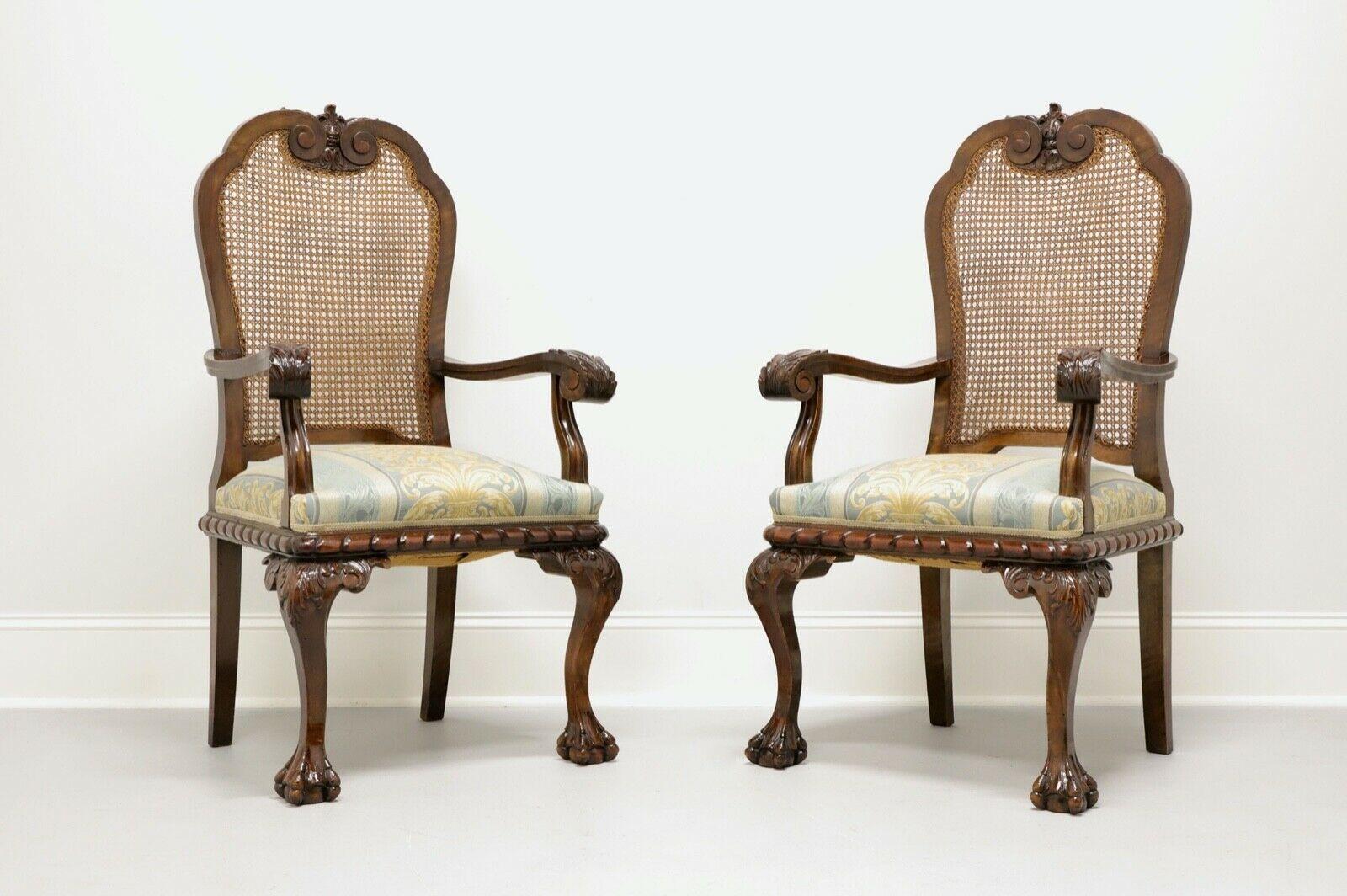A pair of antique Chippendale style armchairs, unbranded. Walnut with cane backs and upholstered seats. Highly carved seat back, arms, seat base, knees and ball in claw feet. Likely made in the USA, in the very early 20th Century.

Measures: