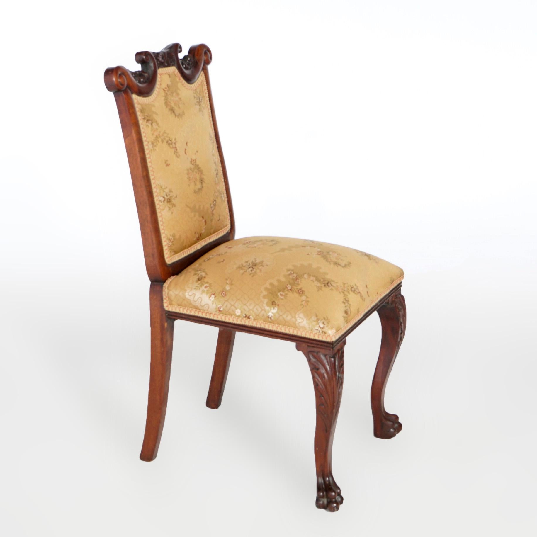 An antique Chippendale style side chair offers mahogany frame with carved scroll form crest having flanking scroll elements over upholstered back and seat, raised on cabriole legs with carved acanthus knees and terminating in paw feet, 19th