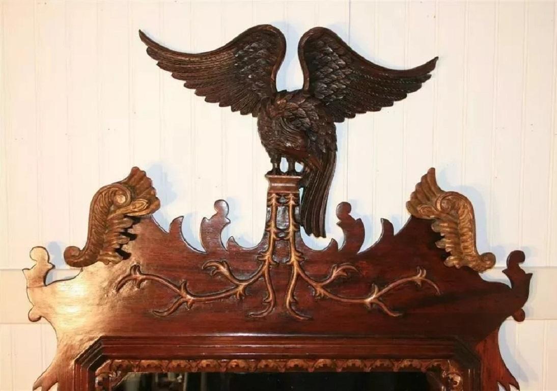 Antique Mirror in stile Chippendale in mogano e legno dorato con uccello Phoenix. L'oggetto presenta intagli decorati in oro dorato e un frontone con uccello fenice alato. Circa all'inizio del XX secolo. Misure: 71