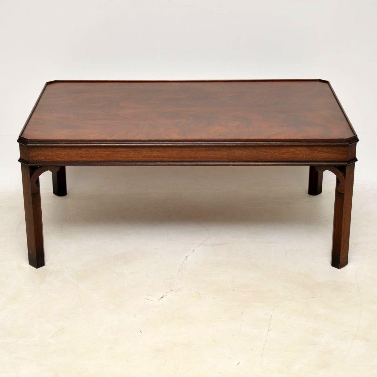 Large antique Chippendale style mahogany coffee table in good condition dating to circa 1950s period. The top is a well figured flame mahogany surrounded by a short top edging. The legs are chamfered and there are shaped brackets joining up either
