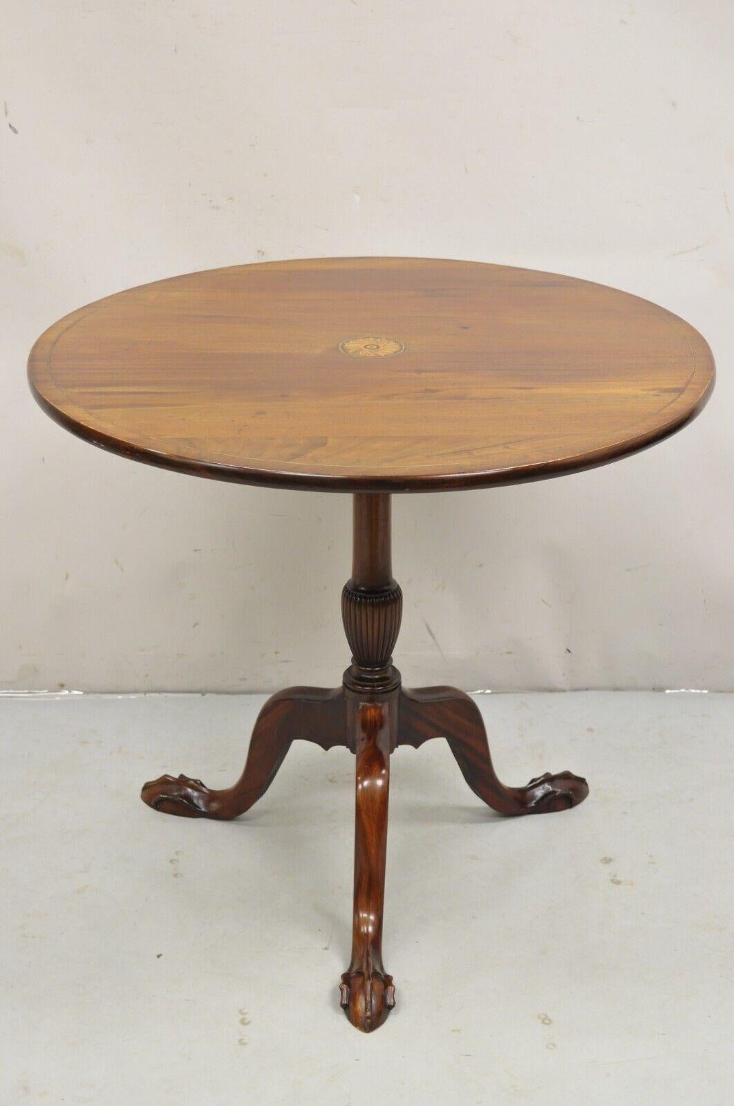 Antique Chippendale Style Round Tilt Top Pinwheel Inlay Ball and Claw Side Table. Item features tapered ball and claw feet, pinwheel and pencil inlay to top, beautiful wood grain, very nice antique table. Circa Early 20th Century.
Measurements: