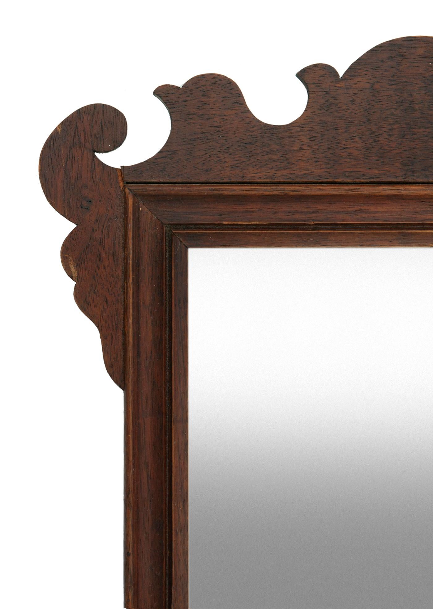 This mirror in a handcrafted frame, the frame, which is not complete in that the bottom, which is straight accross, missing original decorative bottom edge.
The wood is beautiful & the mirror still makes an attractive statement.