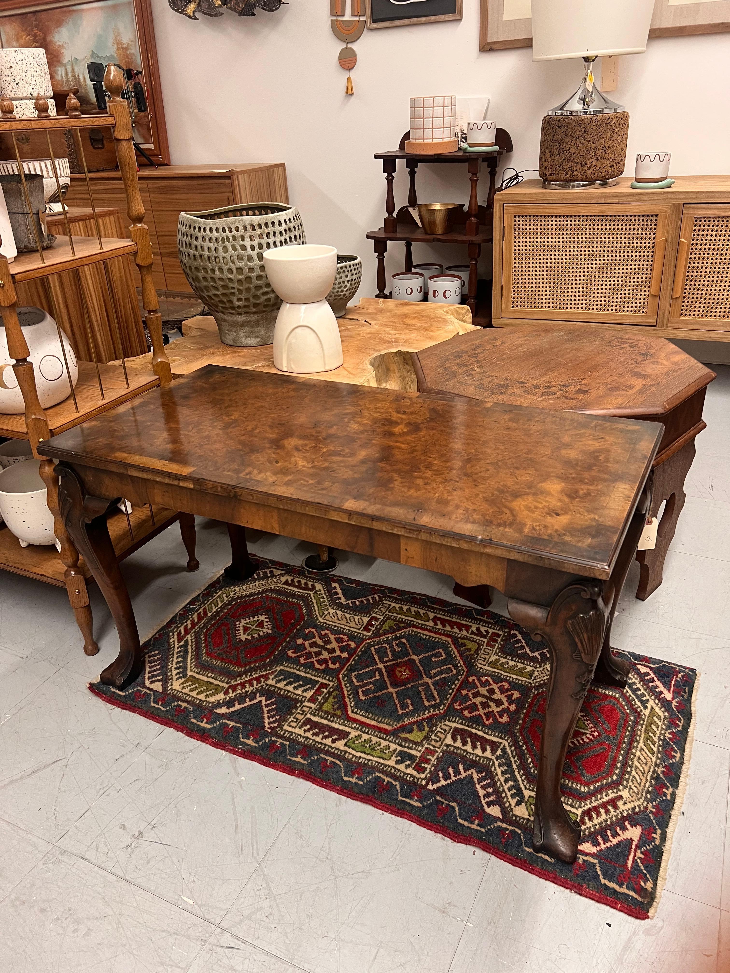   This vintage walnut burl coffee table is a striking piece of furniture that showcases the unique and intricate patterns of walnut burl wood. The tabletop features a glossy finish that accentuates the natural grain and swirling designs, creating a