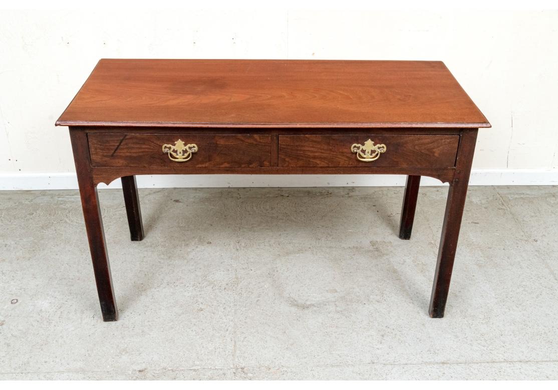 Une très belle table à écrire à deux tiroirs du 19e siècle qui peut servir de bureau ou de console. Les tiroirs à queue d'aronde, les poignées de tirage en laiton et les pieds angulaires sont tous finement polis et satinés. Une sensation très solide