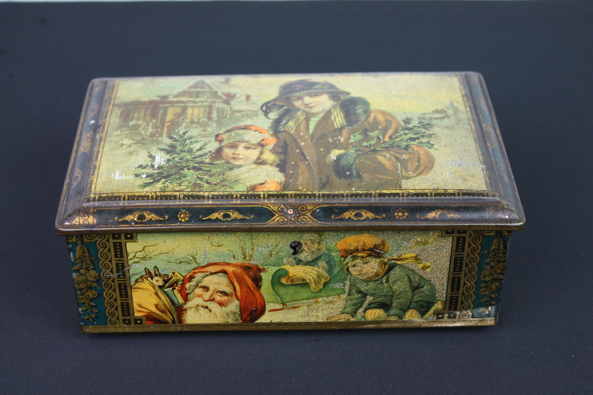 Antique tin theme Christmas. 
A rectangular tin with lid with theme Christmas - Santa Claus - children playing in the snow.
On the lid mother and daughter went to buy christmas trees. On the sides you see Santa Claus with his bag full of gifts and