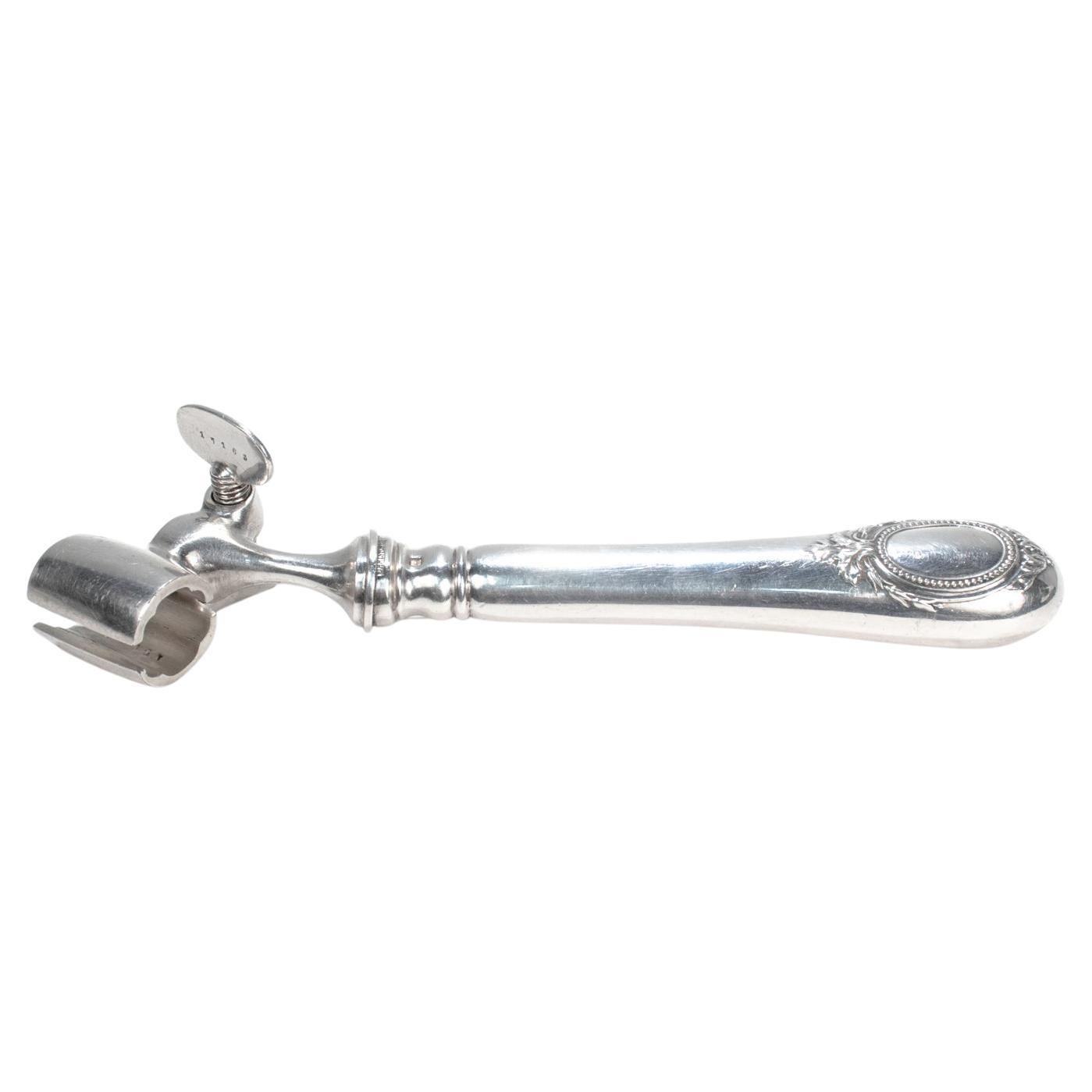 A fine antique Manche a Gigot bone holder.

By Christofle et Cie.

In silver plate. 

In the Baguette pattern.

With an embossed medallion or wreath to the hollow handle handle and a threaded, silver plated bone holder to the top.

Mark for