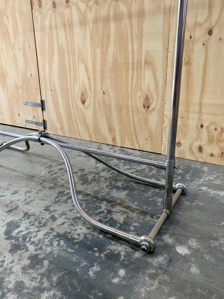 Gorgeous antique French circa 1900 clothes rack in elegantly shaped chrome with beautiful details. The clothes rack has a height adjustable bar to allow more room for shorter items. Perfect for the walk-in-closet, clothes store or showroom.