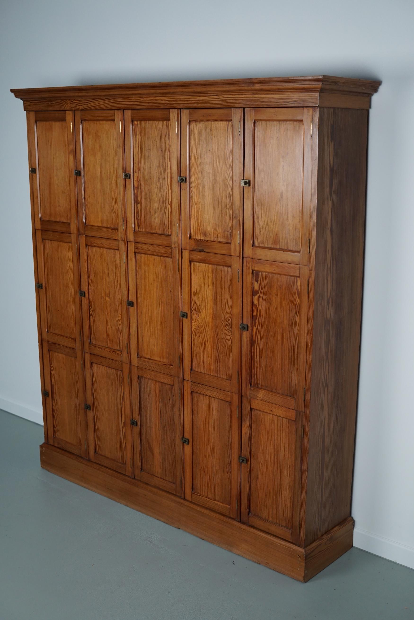 This Dutch pitch pine locker with 15 doors was made around the 1930s in the Netherlands. It was used in a church in the city of The Hague to store personal bibles from the priests. The interior dimensions of the compartments are: D W H 23 x 25 x 46