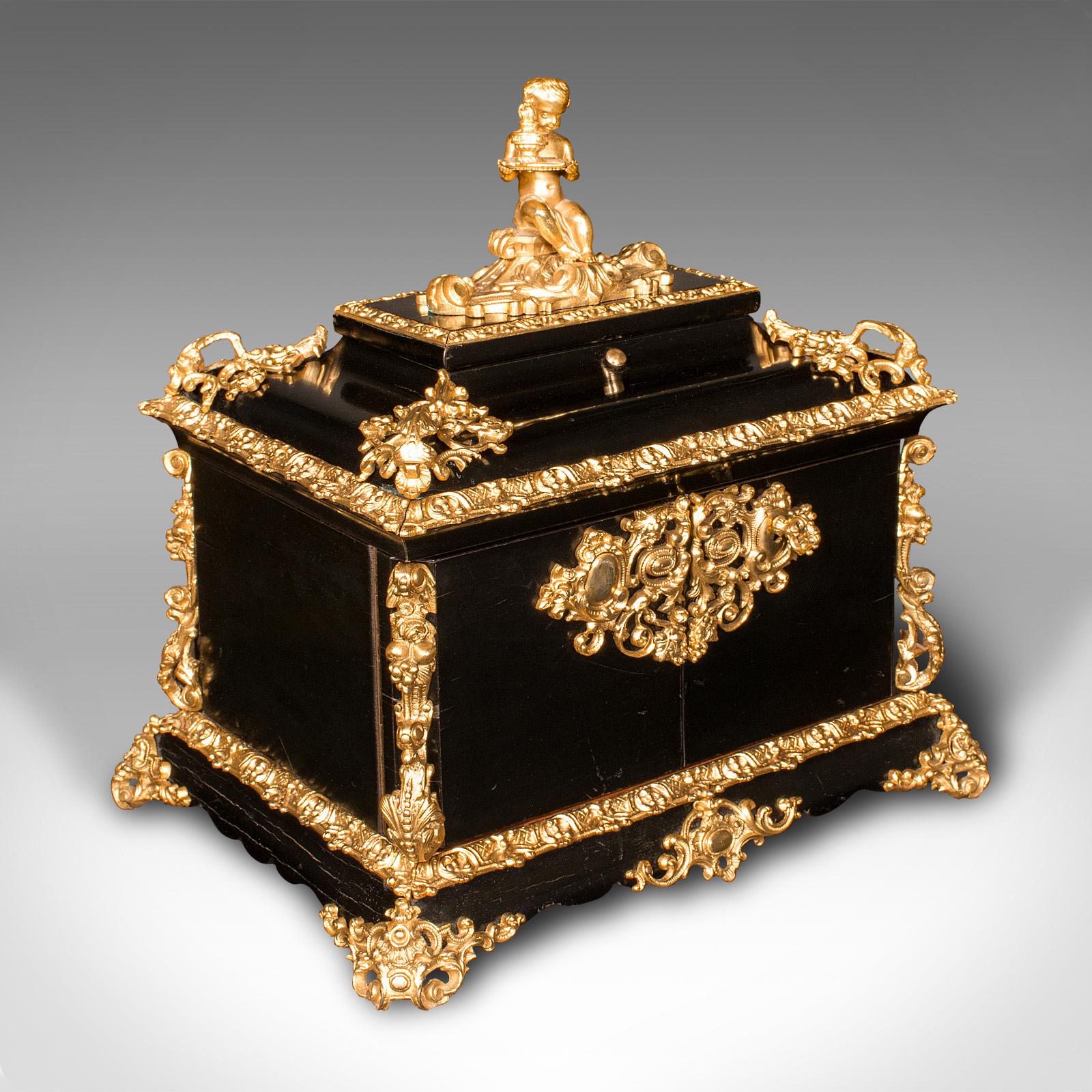 
This is an antique cigar humidor. A Continental, ebonised mahogany and gilt metal Petit Corona case, dating to the mid Victorian period, circa 1860.

Beguiling humidor, with a profusion of intricate brightwork
Displays a desirable aged patina and