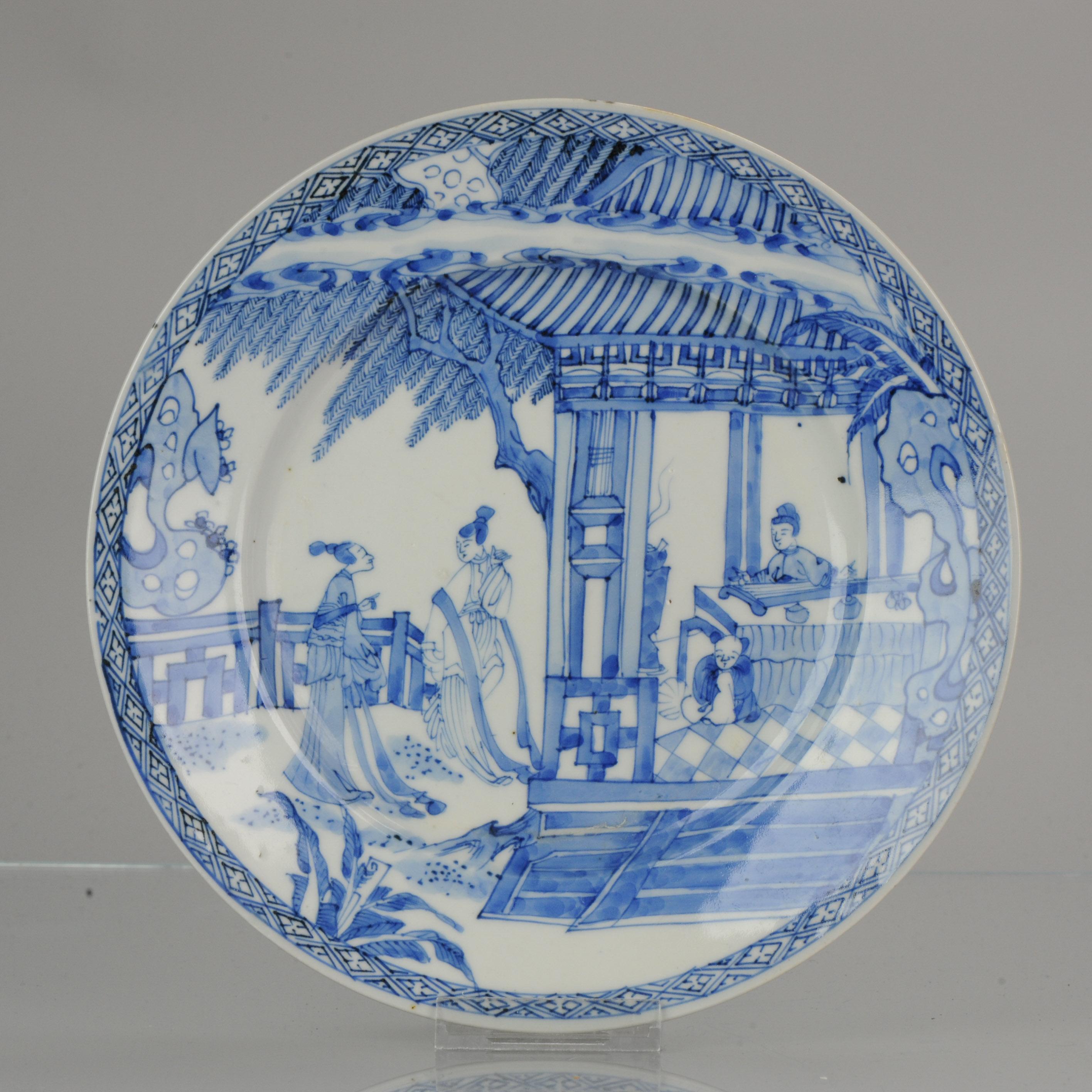 A very nicely decorated Japanese Porcelain dish in Chinese style. Marked at base.

There is an underglaze blue bird mark at the base.

The central scene is of a busy pagoda garden, two elegant ladies are next to a large house. Inside the pagode