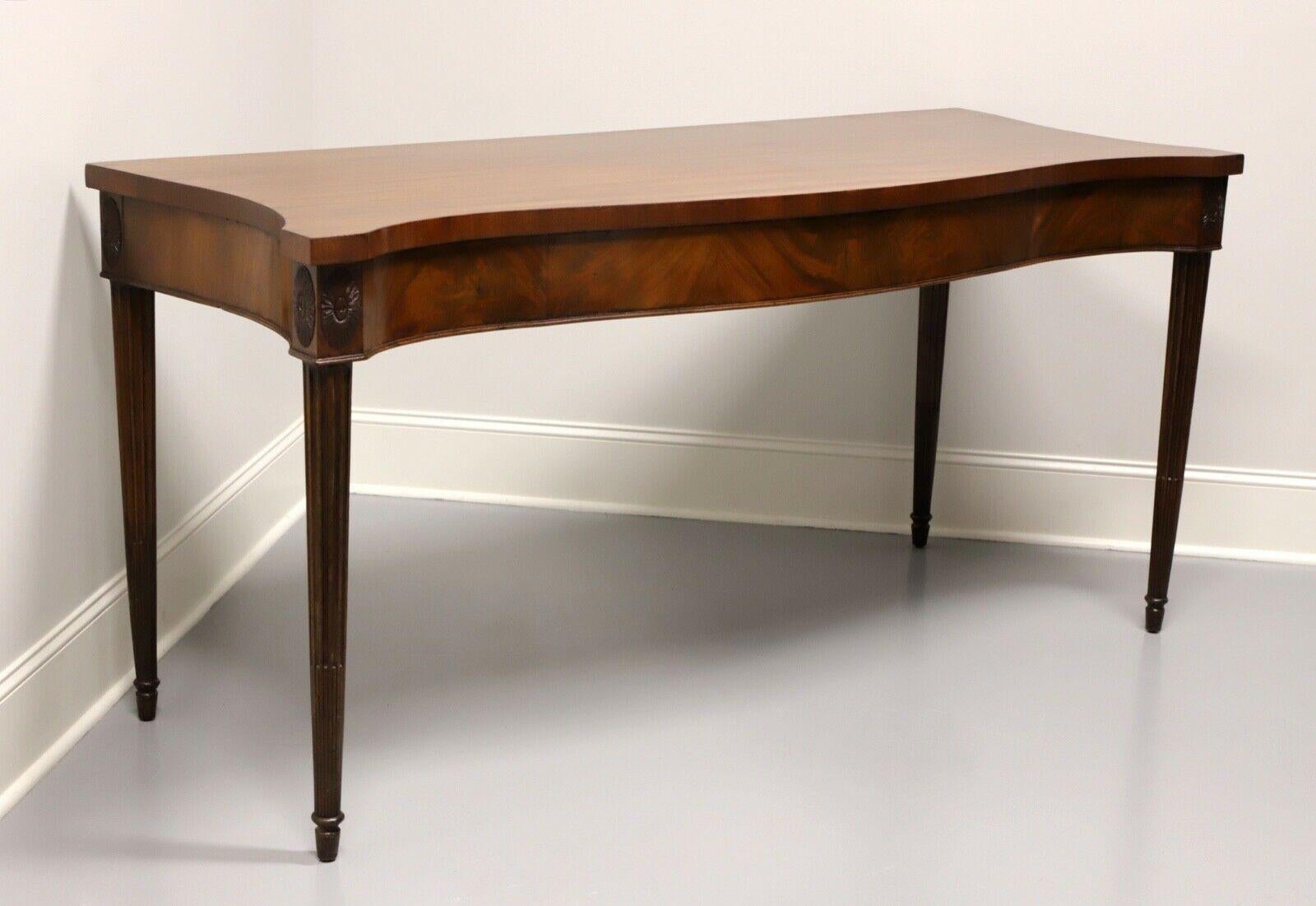 An antique George III style serpentine serving table, no makers mark. Made circa 1800, possibly in England or the USA. Mahogany with flame mahogany veneers to front of apron. Features extra deep top, serpentine front, carved medallions to knees and