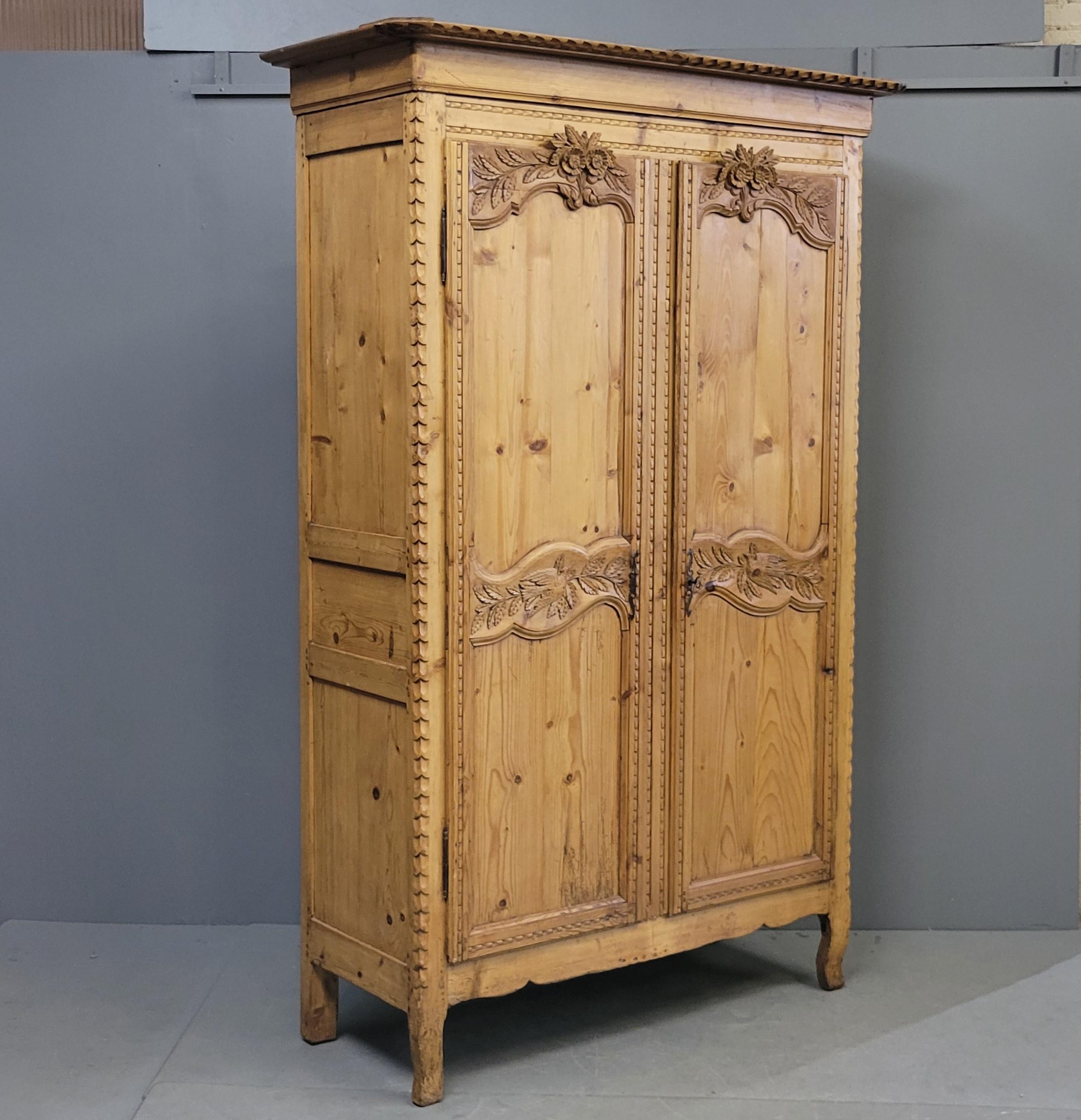 An absolutely stunning antique late 19th century French Provincial pine wedding armoire. Note the beautifully hand carved doves and flowers which indicate that this is a wedding armoire. Note the wear on the feet from over a century of use. Narrow
