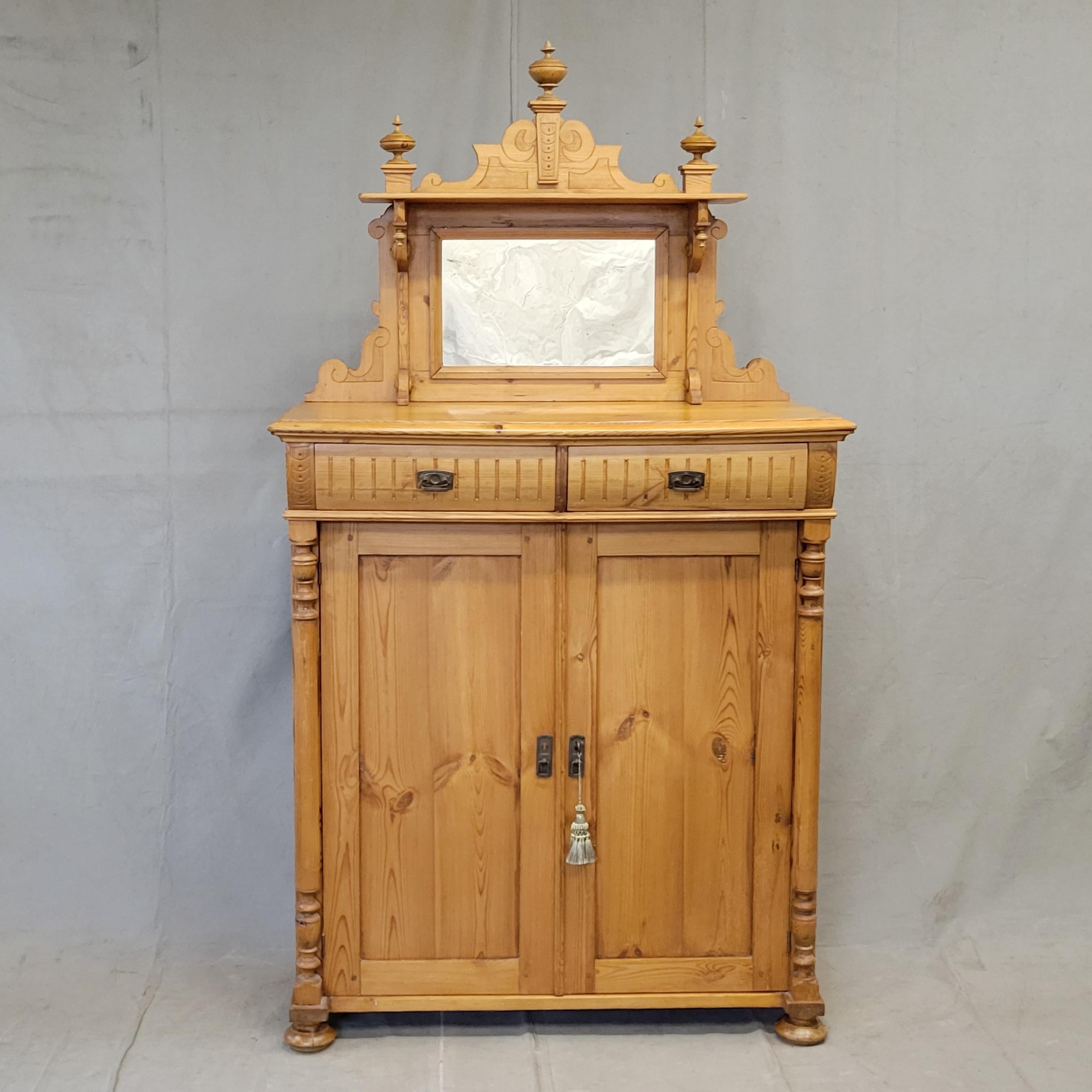 Questa splendida credenza svedese antica, risalente al 1880 circa, è sormontata da una corona a specchio impreziosita da terminali e intagli decorativi. Il buffet stesso è ornato da scanalature sui cassetti, colonne tornite e piedini a bun... oltre