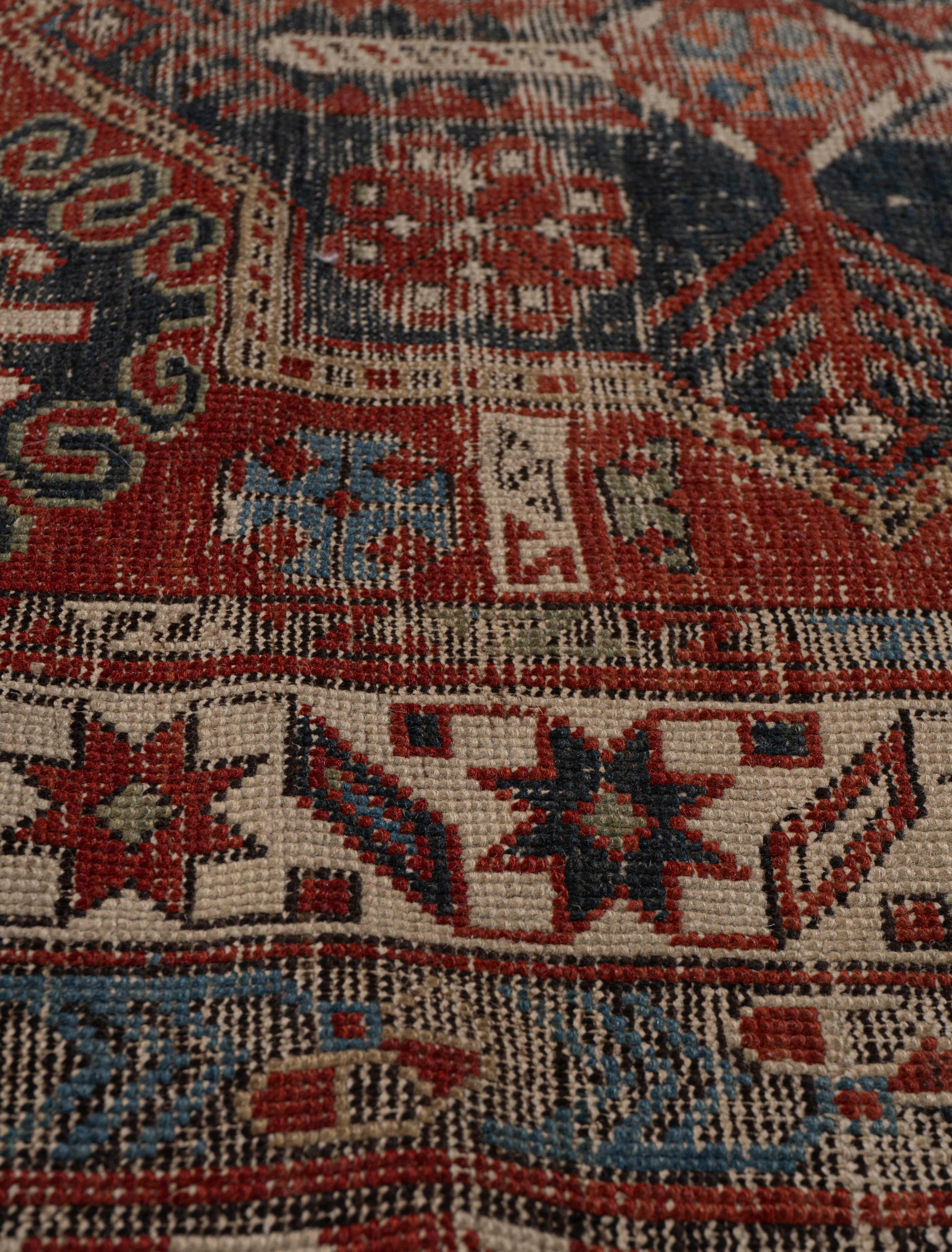 5'3 X 10'. Légèrement usé, ce tapis tissé à la main a des poils bas qui ajoutent à sa patine et à sa beauté. Le tapis a une base solide et résistera aux rigueurs d'une utilisation quotidienne normale. Couleurs : brique/bleu/ivoire/or/vert/noir.