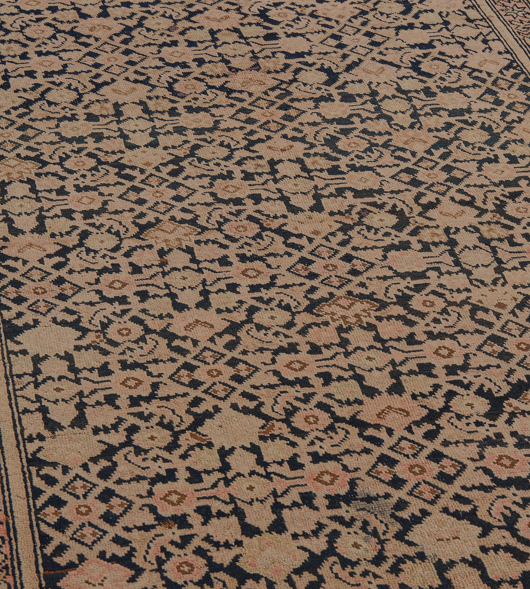 This antique, circa 1900, Karabagh runner has a charcoal field with an overall buff-brown, shaded pink and caramel-brown herati-pattern, in a terracotta-pink border of angular buff-brown vine linking stellar flowerheads between buff-brown and narrow