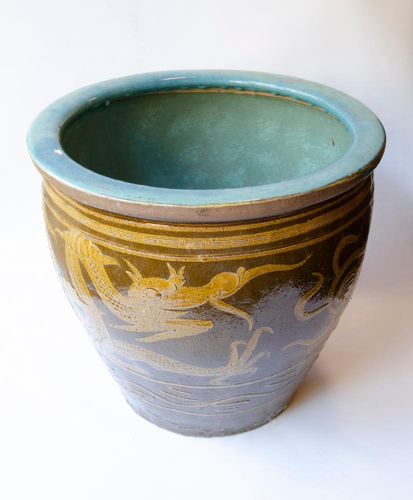 Antique Chinese glazed ceramic egg cup. This brown glazed stoneware urn displays vibrant turquoise tones within. Large egg planter currently being used as an outdoor planter. It has a brown background with an engraved and embossed motif of golden