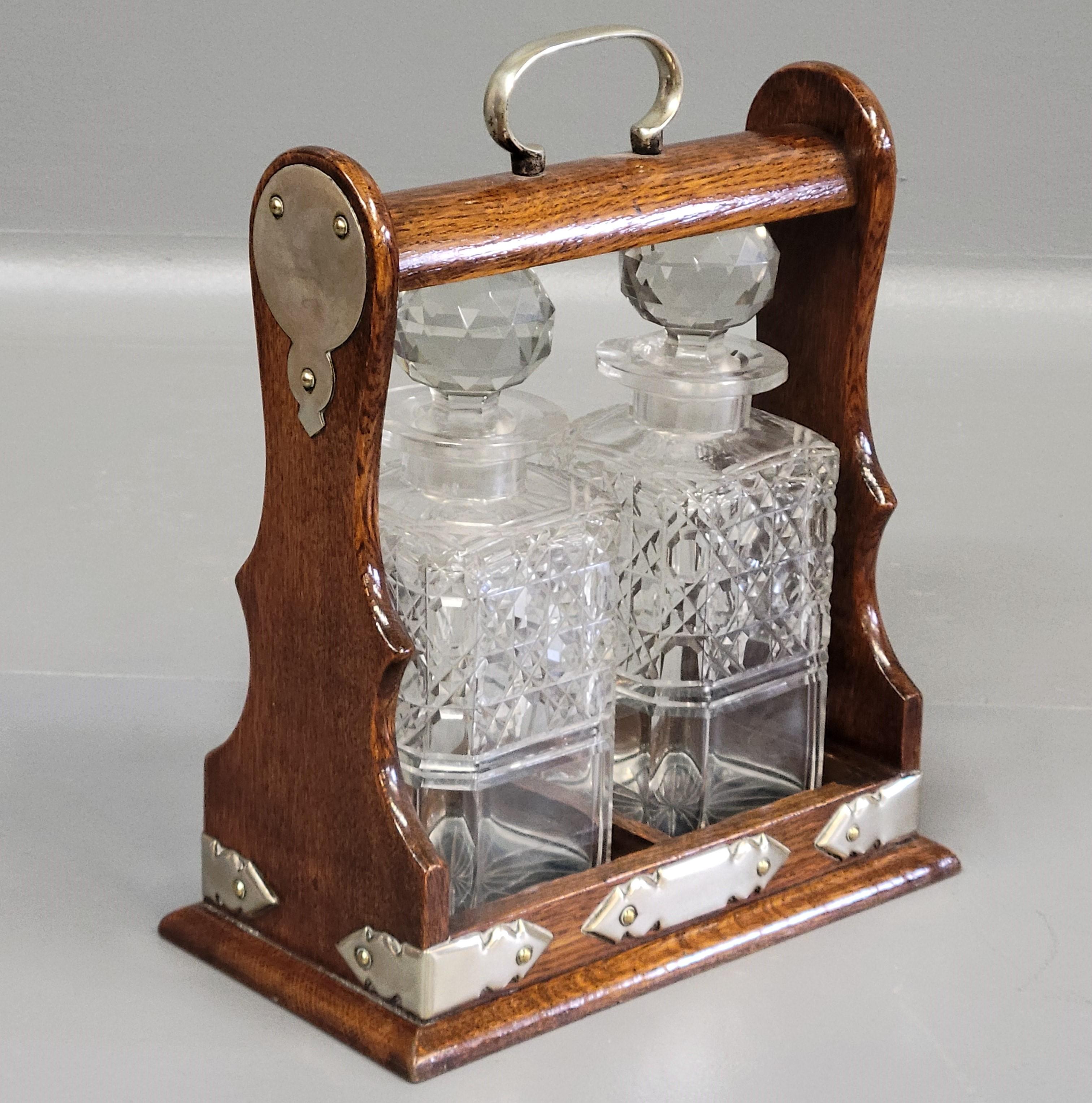 A gorgeous antique circa 1900 English two bottle cut crystal and oak tantalus. The oak case is in good condition with a locking mechanism which includes the key. The cut crystal bottles are 9