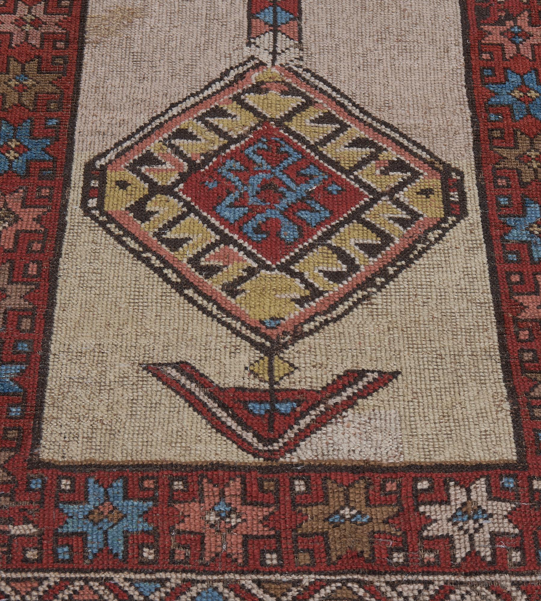 This antique, circa 1900, Serab rug has a shaded ivory and camel-brown field with a bold central lozenge medallion with a large central brick-red lozenge containing a shaded blue hooked vine surrounded by a golden-yellow band of chocolate-brown