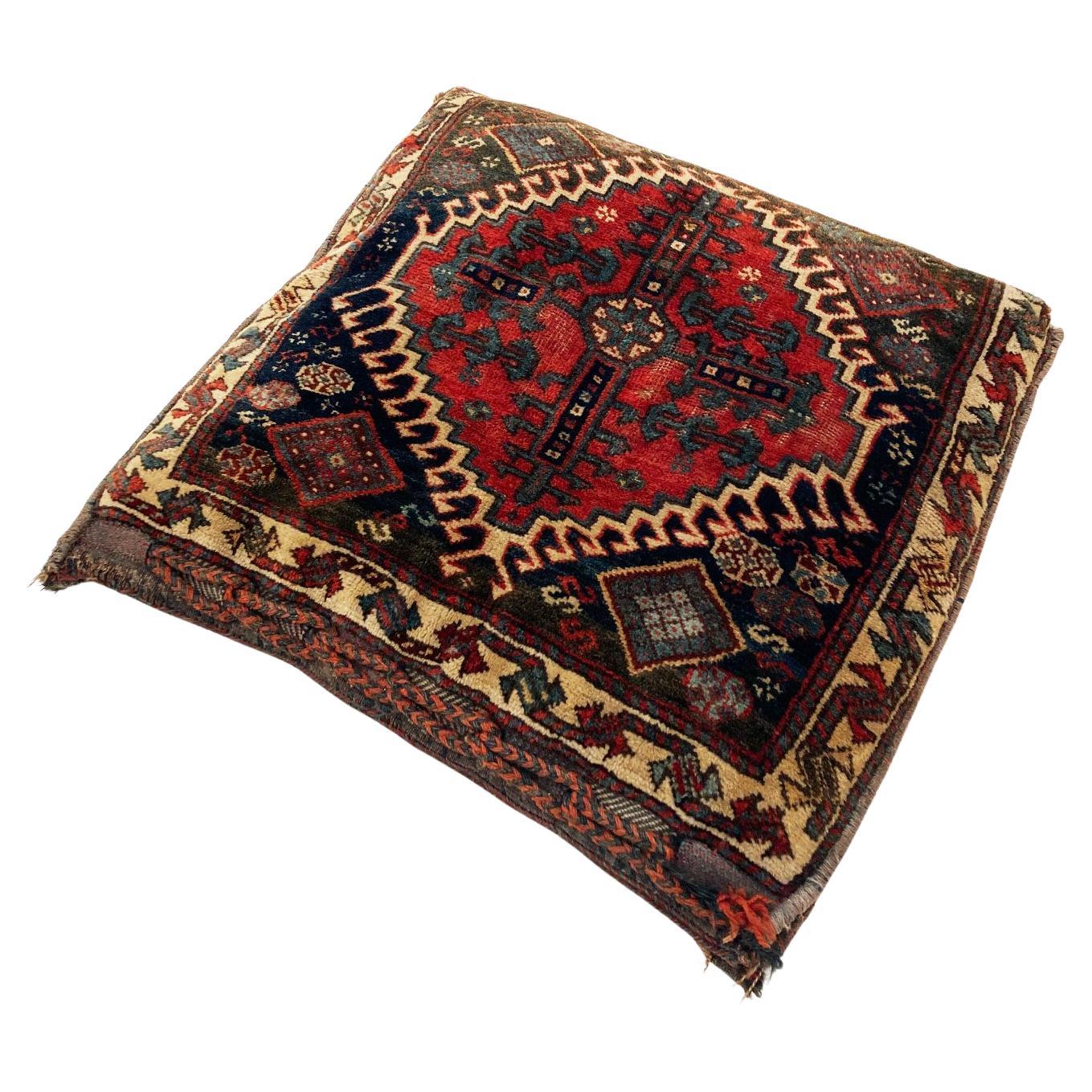 Superbe sac à main tribal persan A.I.C. Khorjin, datant de 1900, qui a été transformé en coussin tribal avec un dos multicolore uni et coordonné. Les couleurs vibrantes se composent de tons chauds de rouge brique, de rouille, de gris chauds et