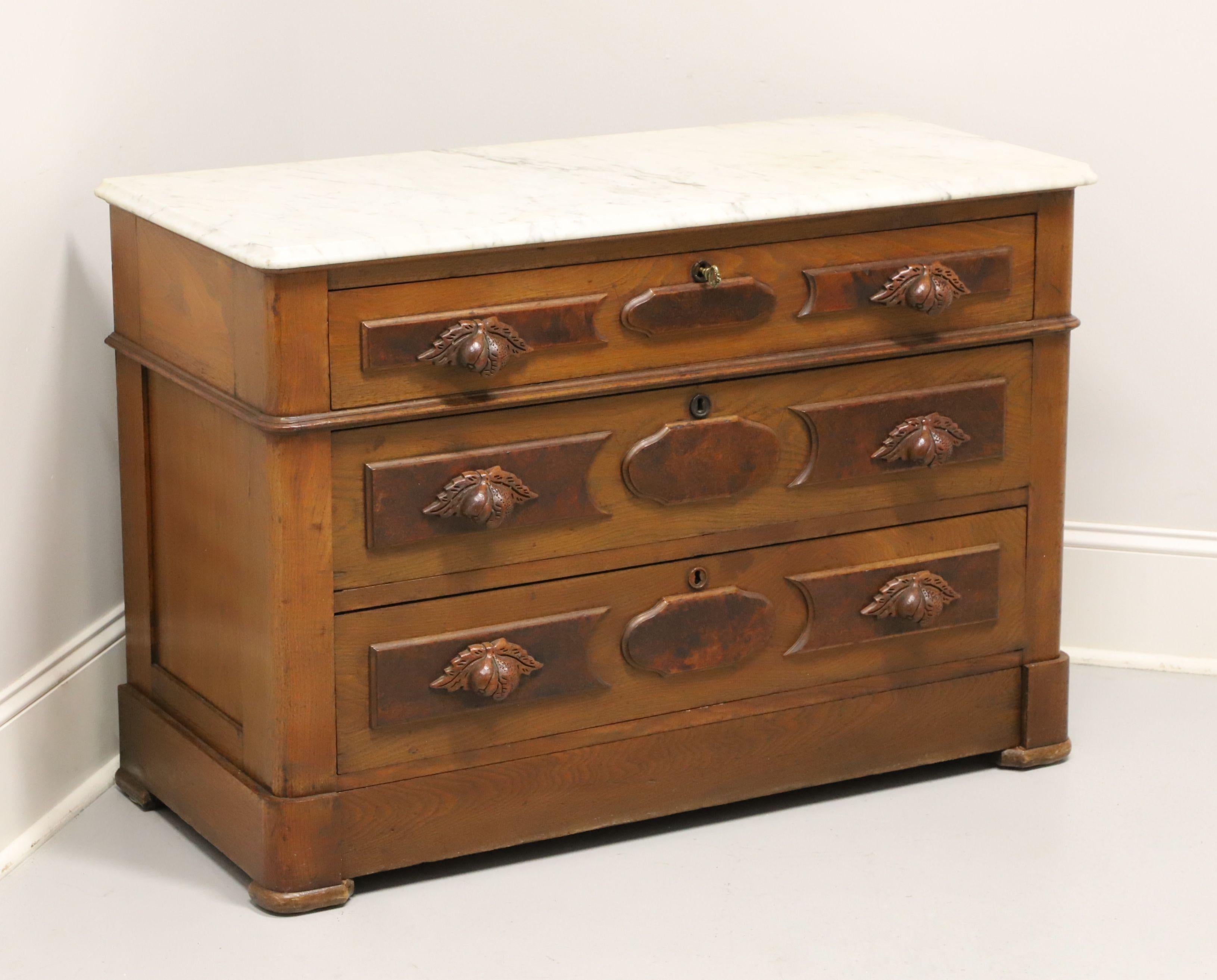 An antique Victorian style marble top four-drawer chest, unbranded. Walnut with burl walnut to drawer fronts, ogee edge marble top, decoratively carved wood handles, brass keyhole escutcheons, solid base and pad feet. Features three upper drawers of