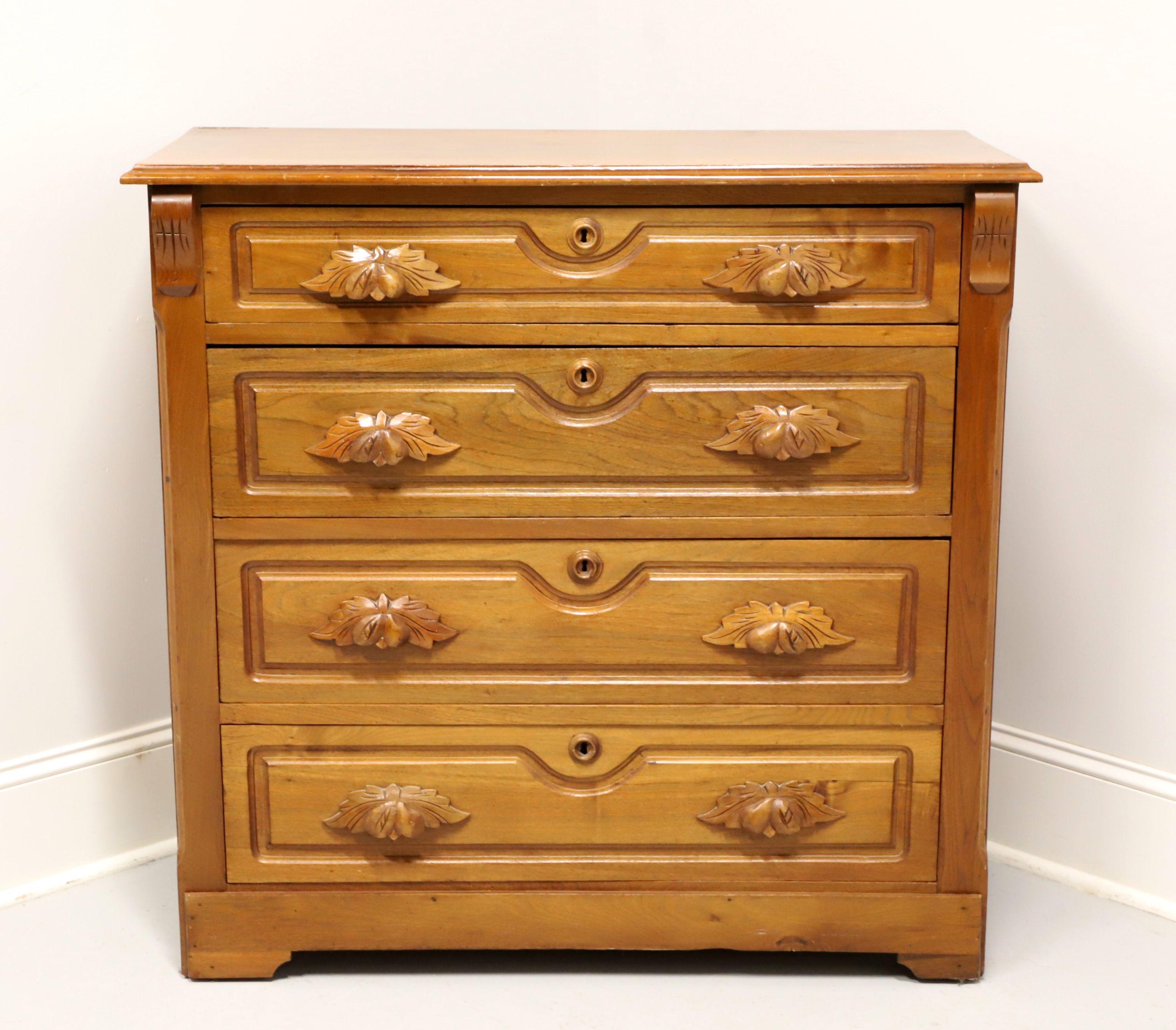 An antique Victorian style four-drawer chest, unbranded. Walnut with a light color finish, decoratively carved handles, front corners & drawer fronts, wood keyhole escutcheons, and bracket feet. Features four drawers of dovetailed construction with