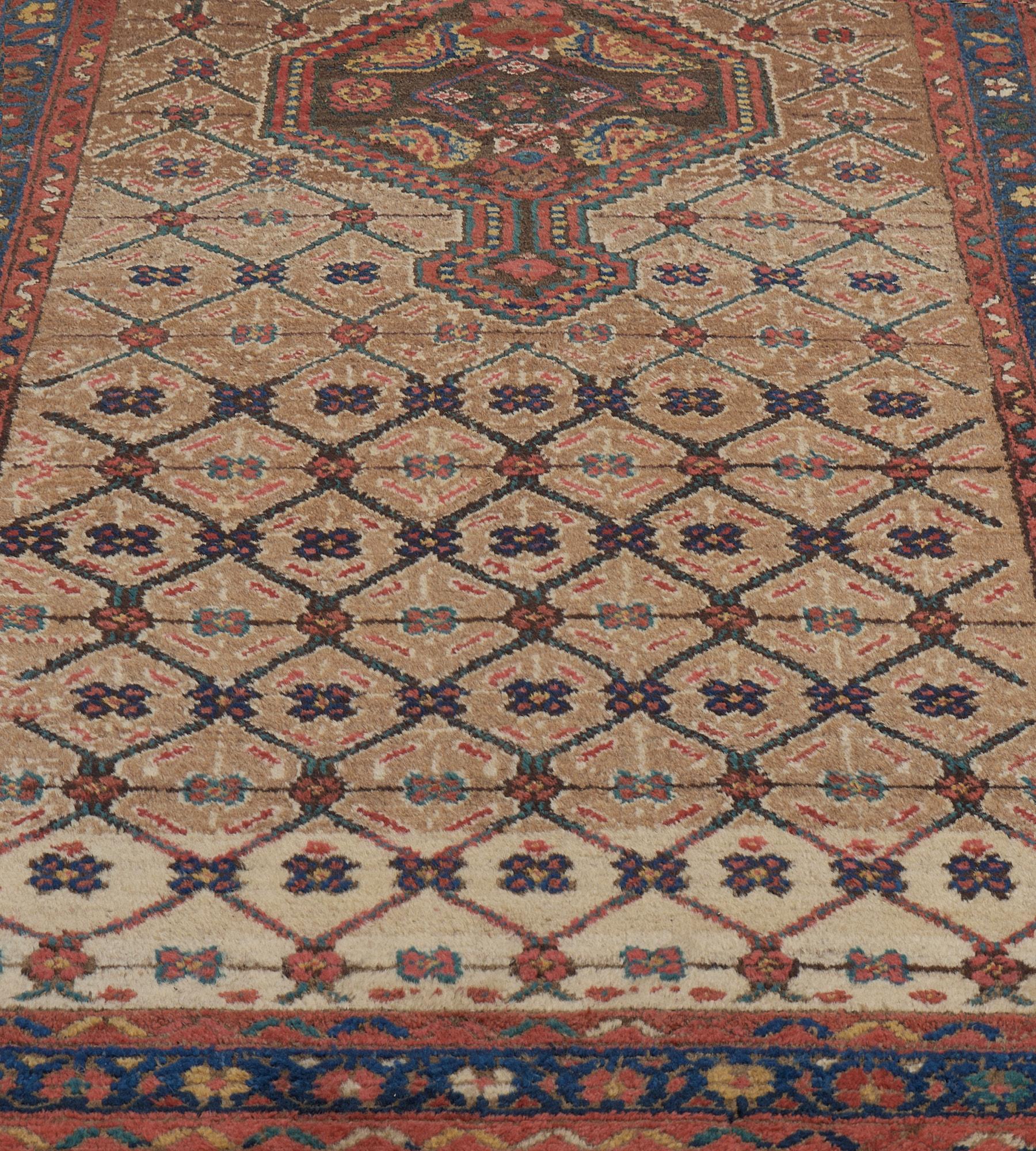 This antique, circa 1900, Persian Serab Runner has a camel-brown field with a light-blue lozenge lattice linked by a tiny flowerhead each lozenge enclosing a delicate polychrome floral motif, around a central chocolate-brown serrated lozenge with