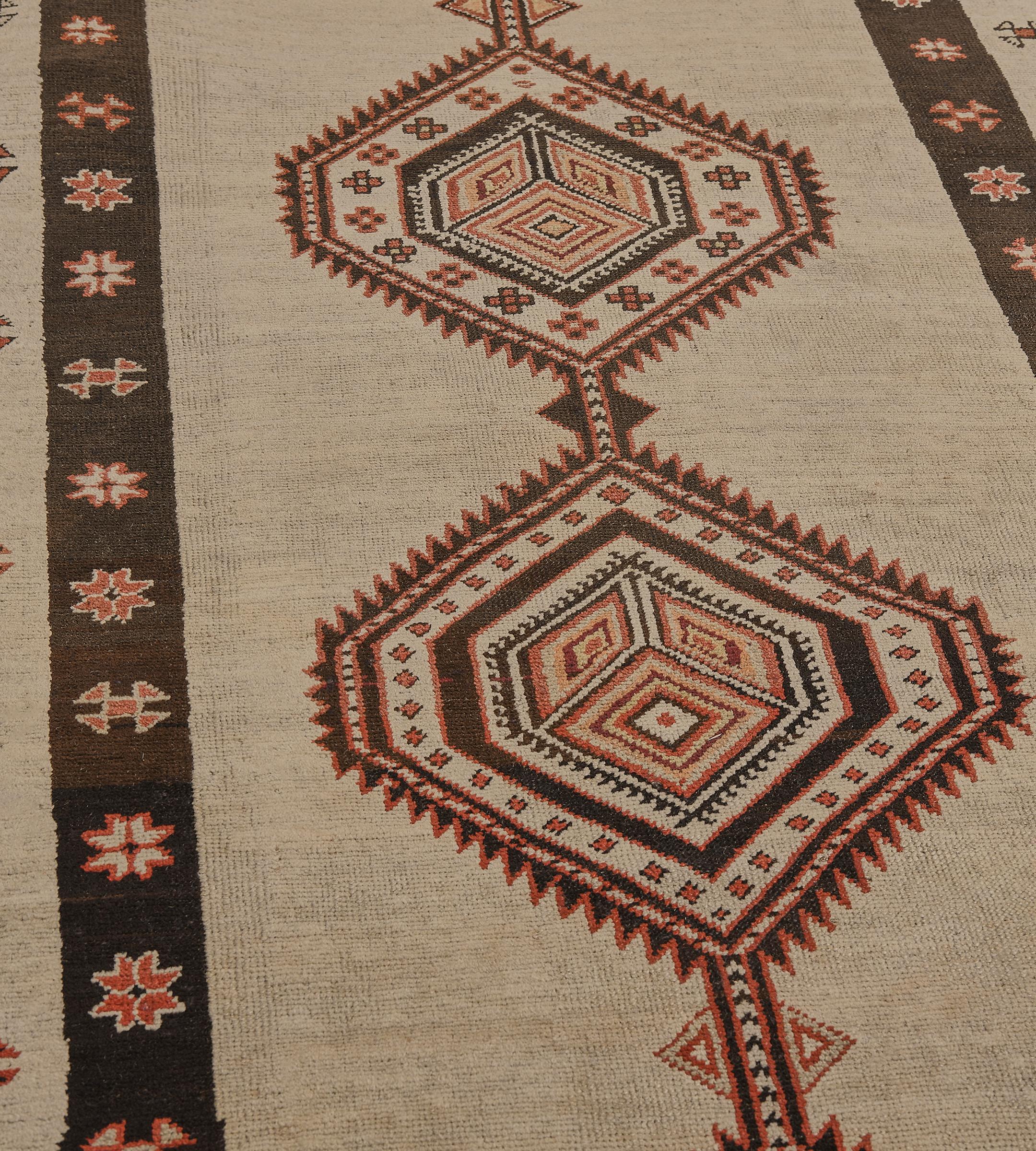 Dieser antike, um 1900 gefertigte persische Serab-Läufer hat ein hellkamelfarbenes Feld mit einem Paisley in jeder Ecke und einer zentralen Säule aus fünf miteinander verbundenen, gezackten Rauten, von denen vier eine zentrale Raute mit drei