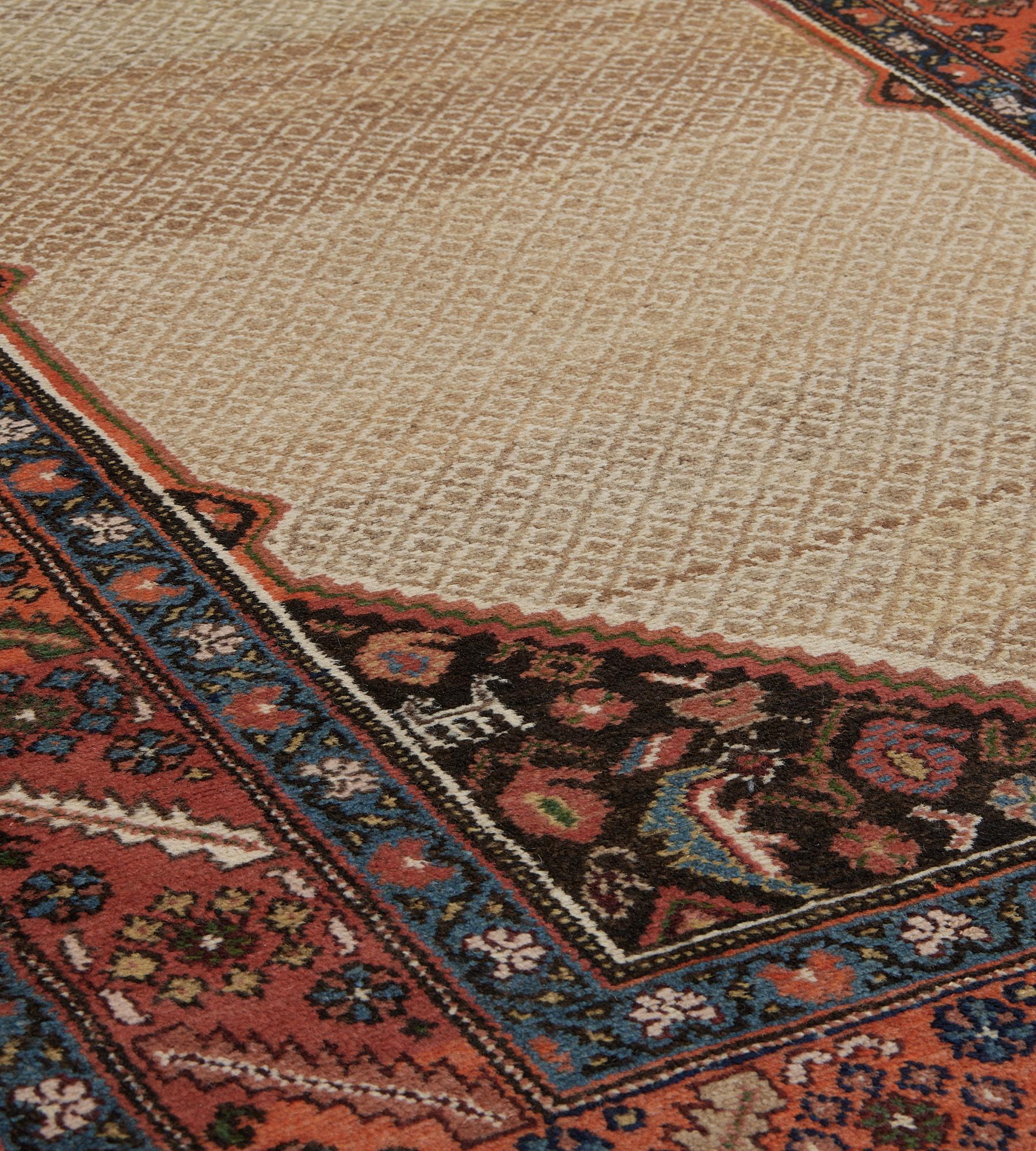 This antique, circa 1900, Serab Runner has an ivory field with a dense camel-brown lozenge lattice around a central charcoal-black serrated lozenge with palmette pendants containing polychrome angular floral vine, the charcoal-black serrated linked