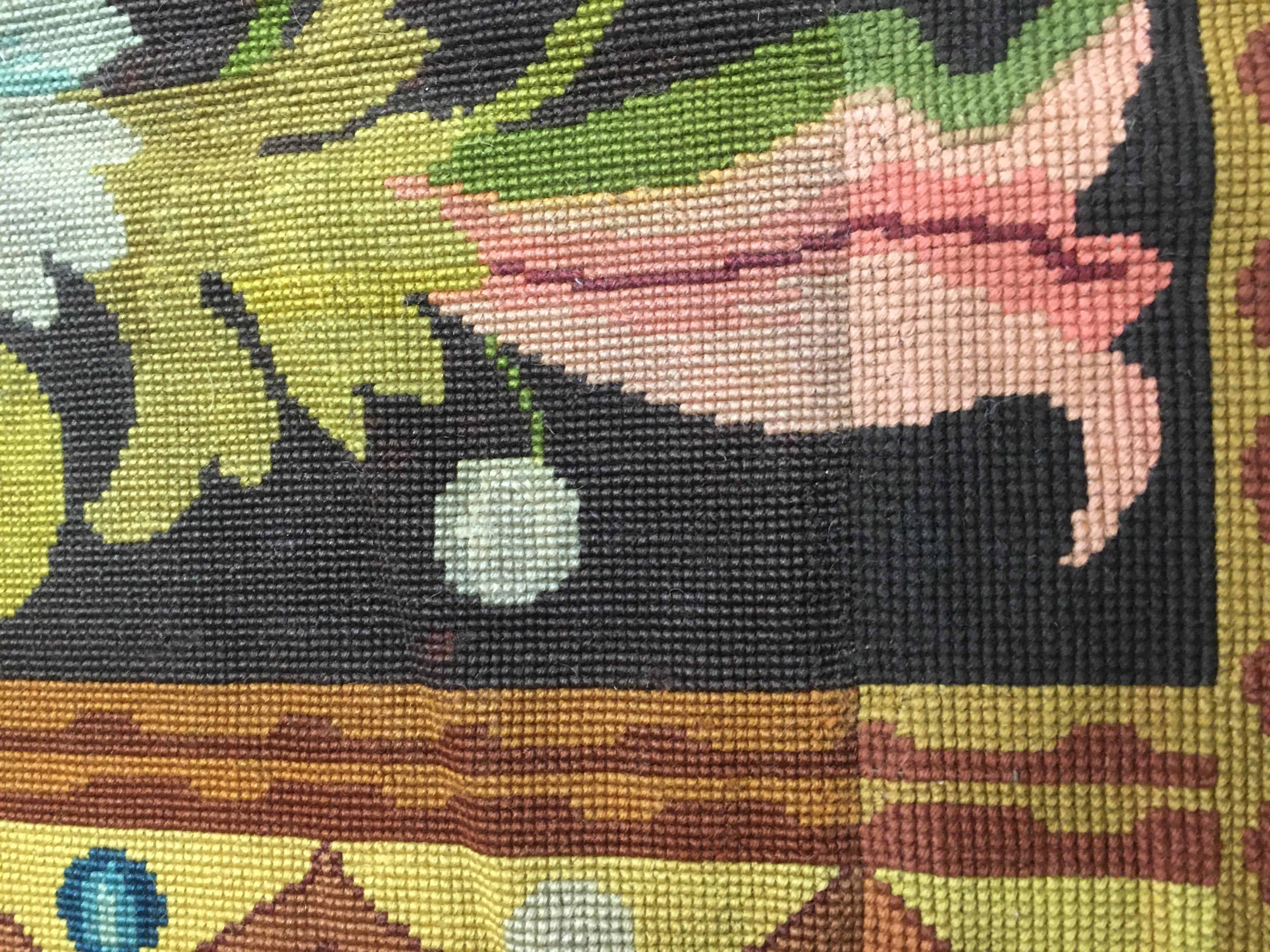 5'9 × 12'8. A striking testament to early 20th-century French textile artistry, this antique needlepoint panel, dating circa 1910, features a harmonious series of repeating floral motifs, elegantly arranged within a structured geometric pattern. The