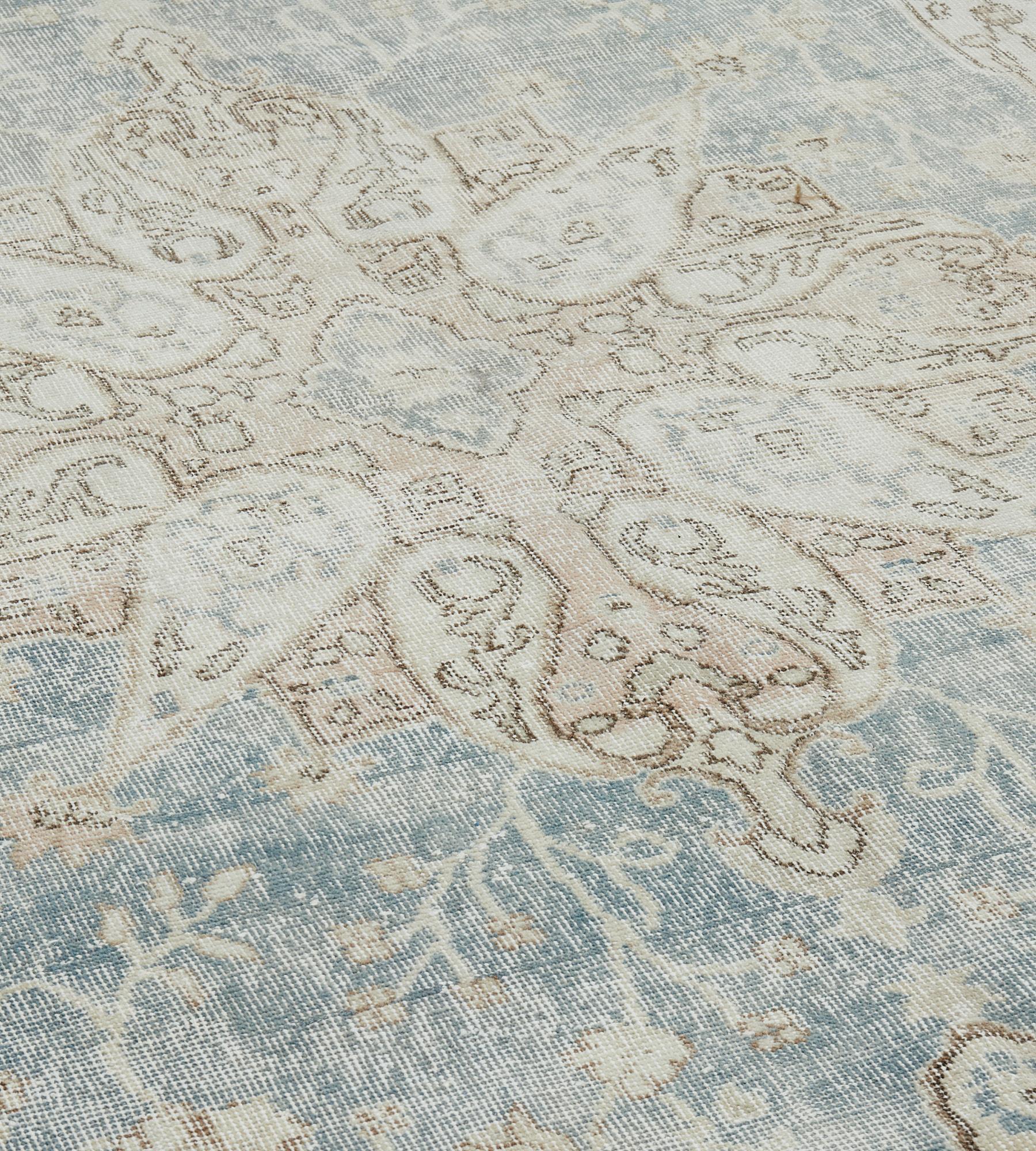 This antique, circa 1910, Anatolian Sivas rug has a light blue field with a central ivory, soft terracotta and pale blue cusped lozenge medallion with palmette pendants surrounded by scrolling palmette and flowerhead vine, the ivory and soft