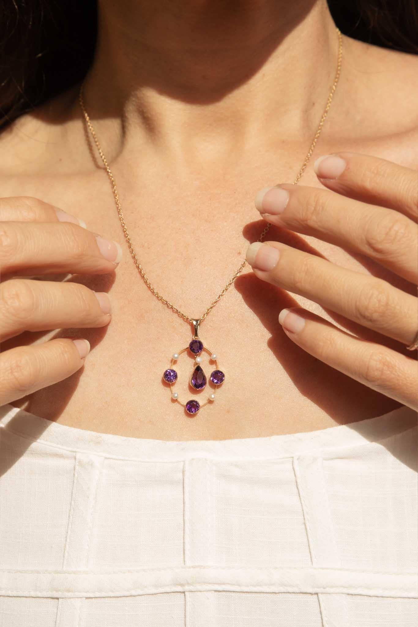 The 8K yellow gold Boheme Necklet showcases deep dark purple amethysts paired with luminous button freshwater pearls. A pear-shaped amethyst takes centre stage, encircled by alternating round amethysts and pearls in a graceful oval design. She is an