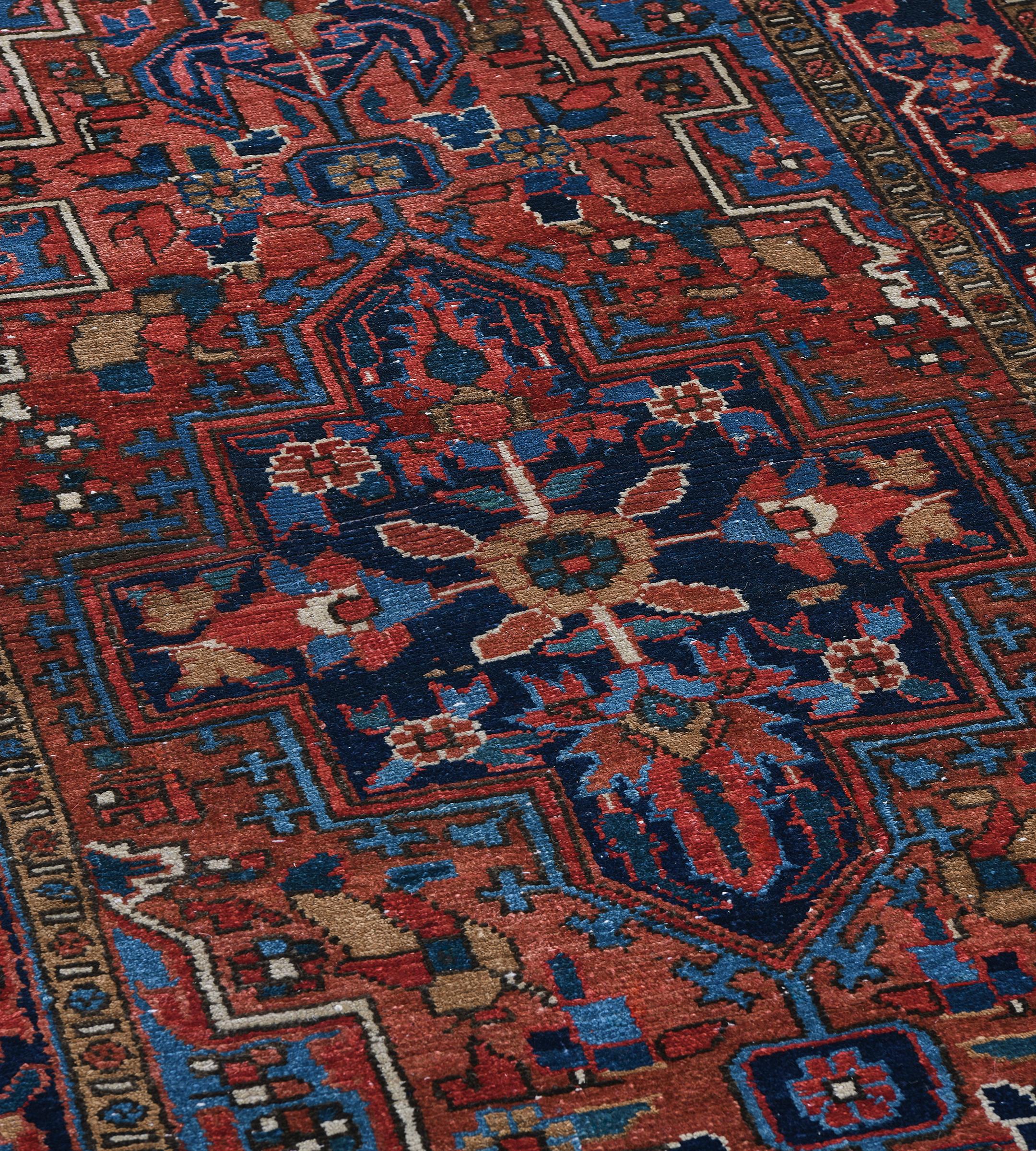 This antique, circa 1920, Persian Heriz runner has a rust field with angular floral and palmette vine around a column of three large stepped lozenges containing a central indigo-blue stepped lozenge each with a central floral lozenge issuing