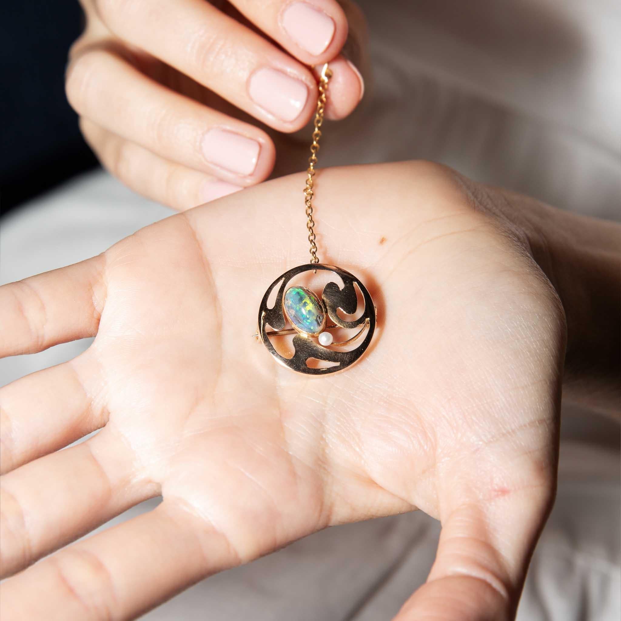 A whimsical reminder of a time long past, the darling Sarah Brooch is a 15 carat rose gold disc with an asymmetrical open pattern and a solid Australian black opal at the centre with a single seed pearl to one side. Fitted with a 50mm safety chain