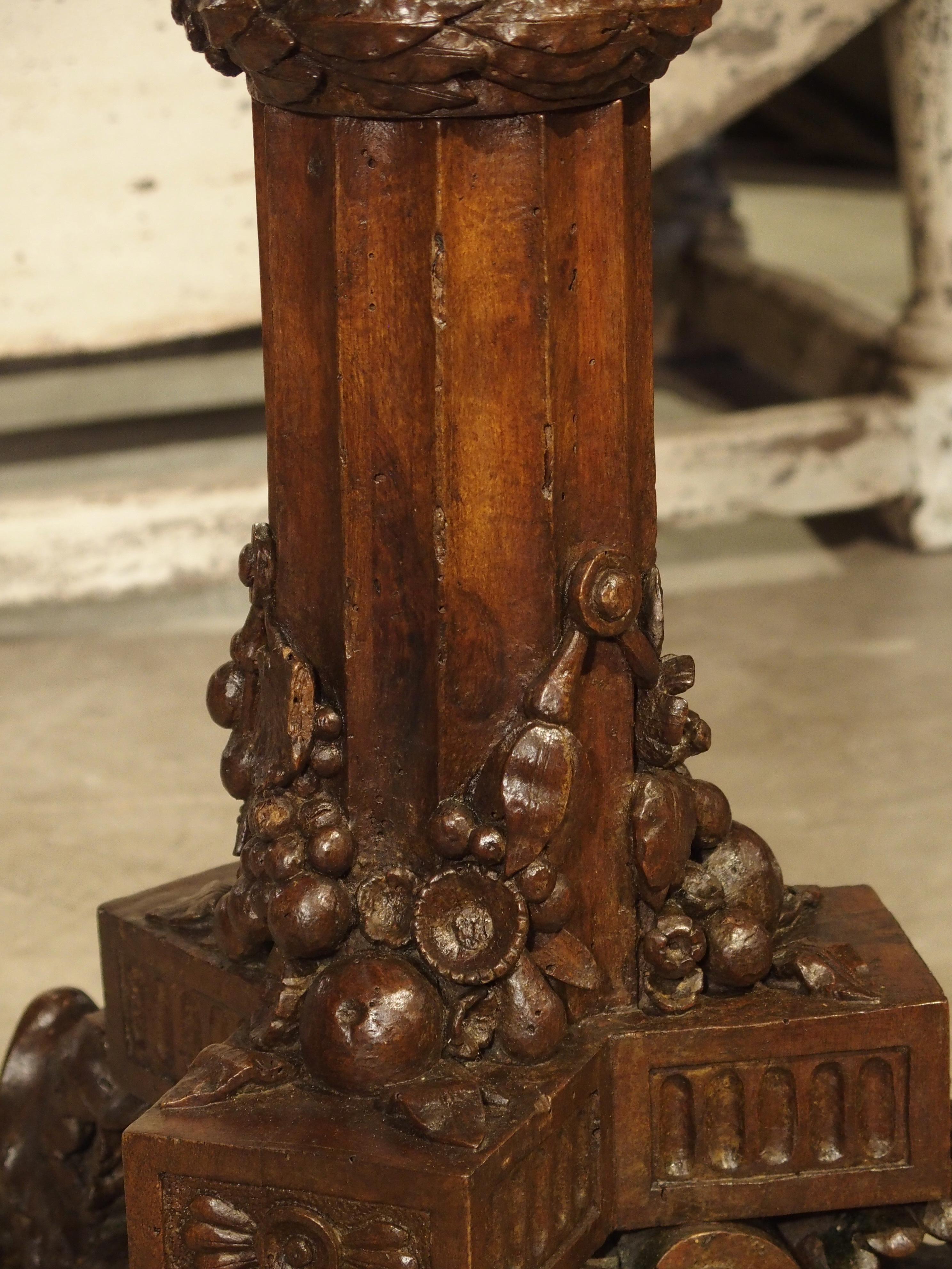 From Genoa Italy, this round walnut wood, bistro table with a marble top has the most spectacular hand carved pedestal. The round column beneath the marble top has Gothic style arches that end at the point where the wreath goes around the column.