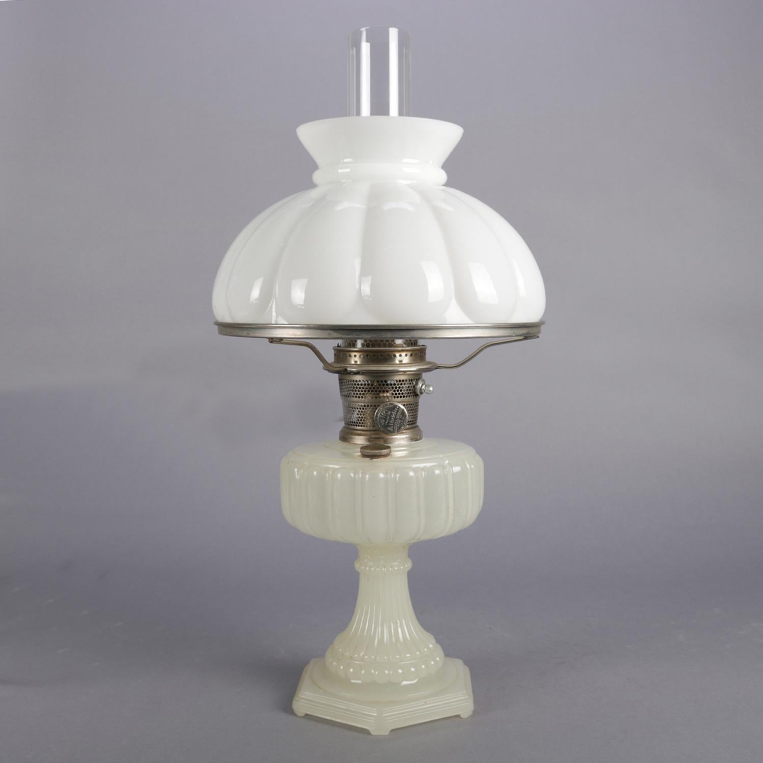Antique Aladdin Co. table lamp features clambroth glass base with melon form font over reeded and beaded pedestal and over footed base, burner with 