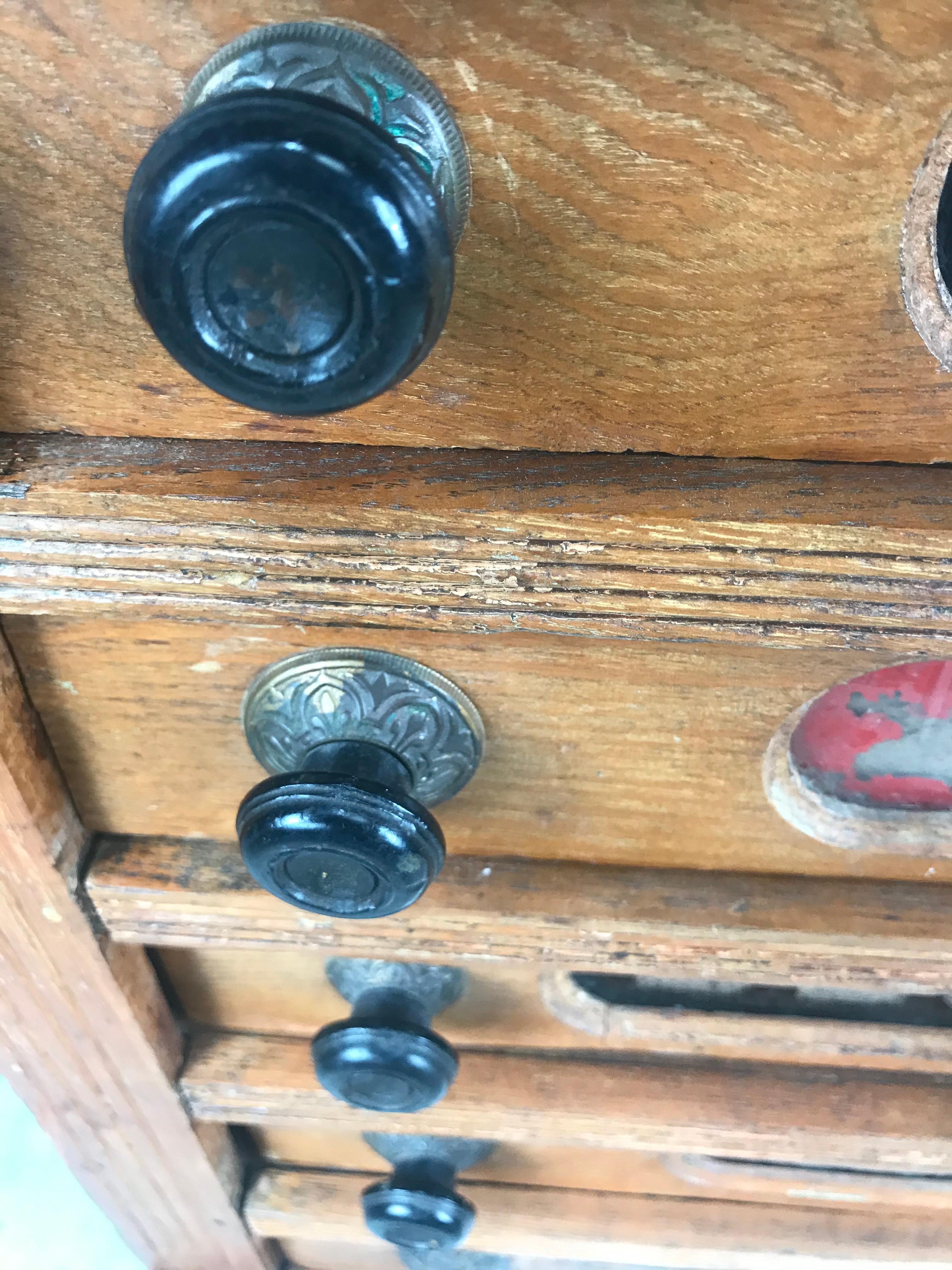 Antique spool cabinet. Made of oak with five drawers. Retains its original reverse painted drawers as well as its original hand pulls, this was used in an old general store to hold sewing notions. Would make an amazing jewelry chest or desk