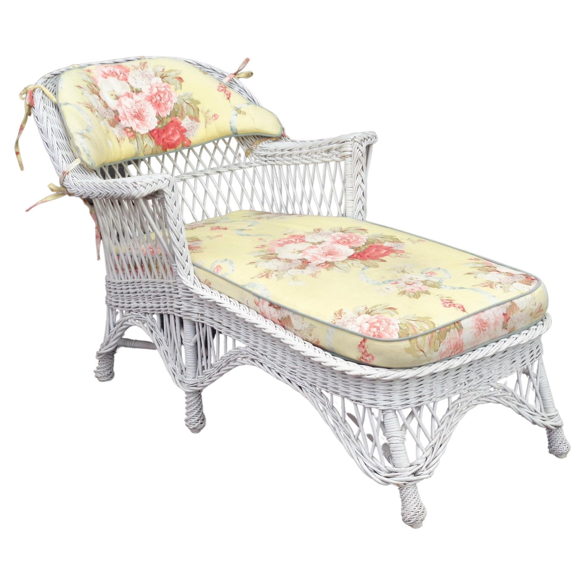 Antique American classic Bar Harbor wicker willow chaise lounge in nice white painted surface. Wood frame work w/ metal strapped spring construction at underside of fabric covered seat. Tightly woven wicker w/ upholstered floral pattern loose seat