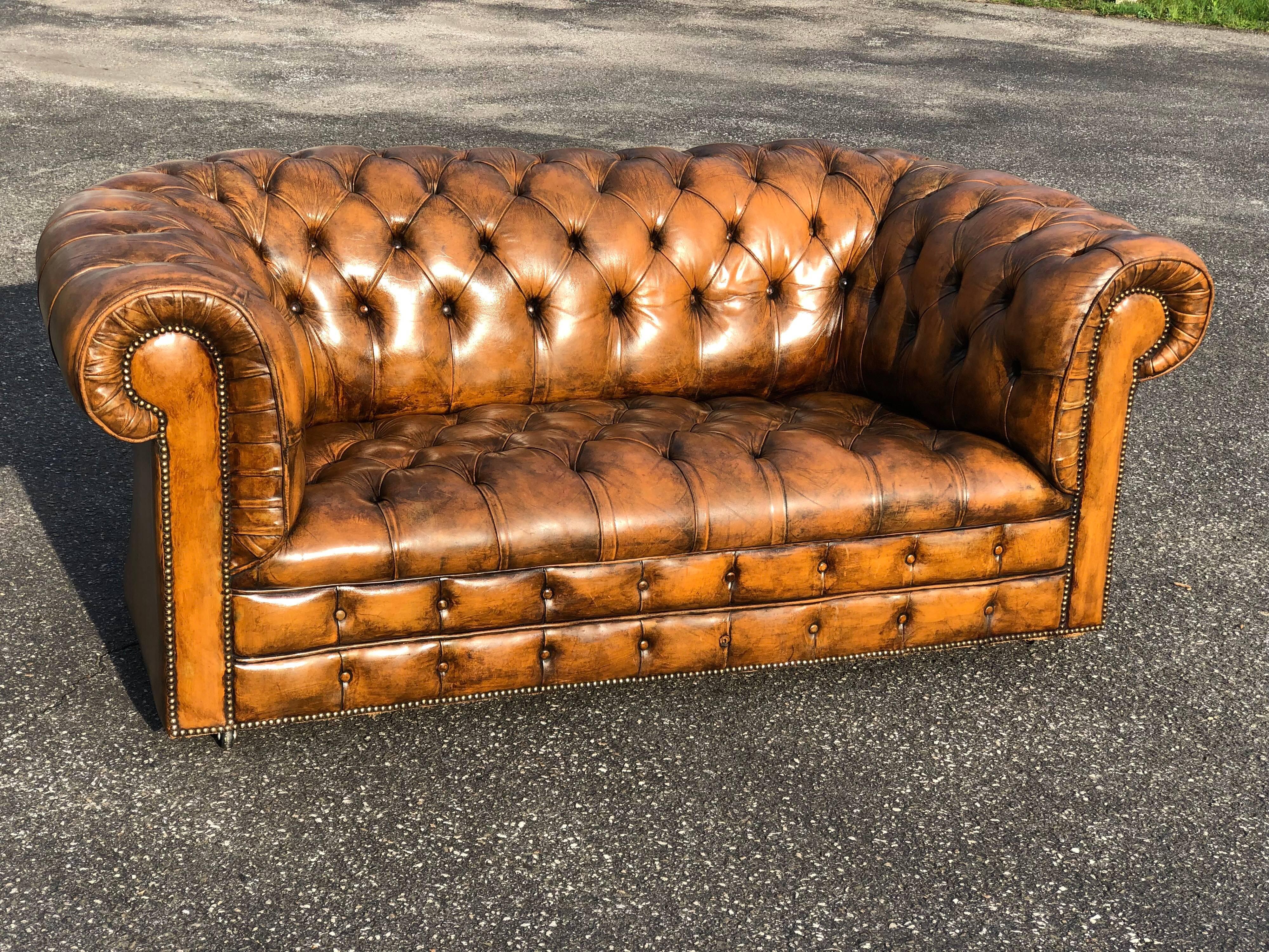 Antique Classic leather Chesterfield love seat. This is the real deal here. Amazing aged patina but leather is in excellent condition. This timeless and Classic sofa and will complement any study, office, bedroom or living space.  It has strong