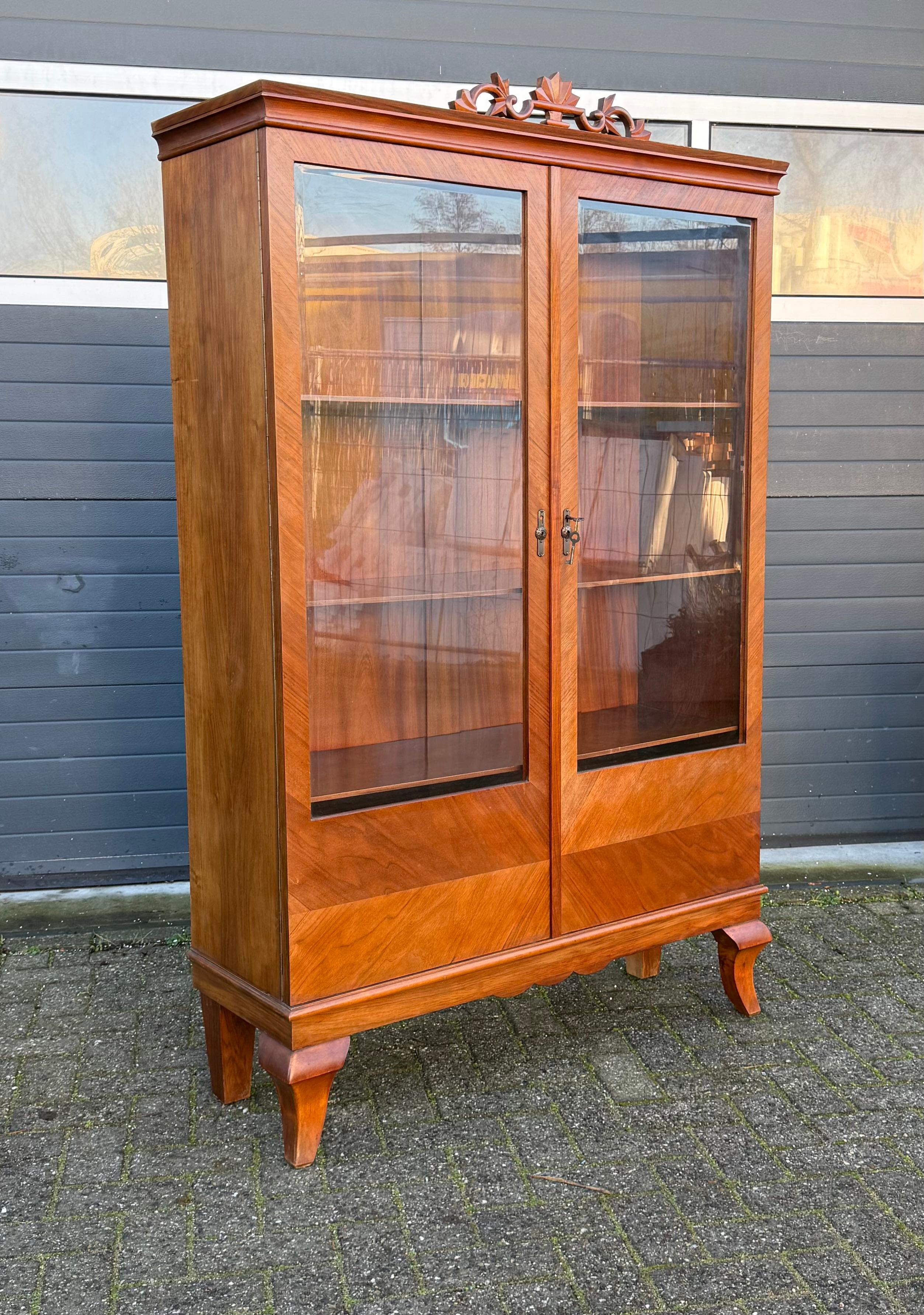 Wunderschön handgefertigte Vitrine aus Nussbaumfurnier der Bauhaus-Ära mit einem Hauch von Expressionismus.

Diese hochwertige zweitürige Vitrine aus den frühen 1900er Jahren mit ihren originalen, abgeschrägten Glaspaneelen ist ein Kunstwerk für