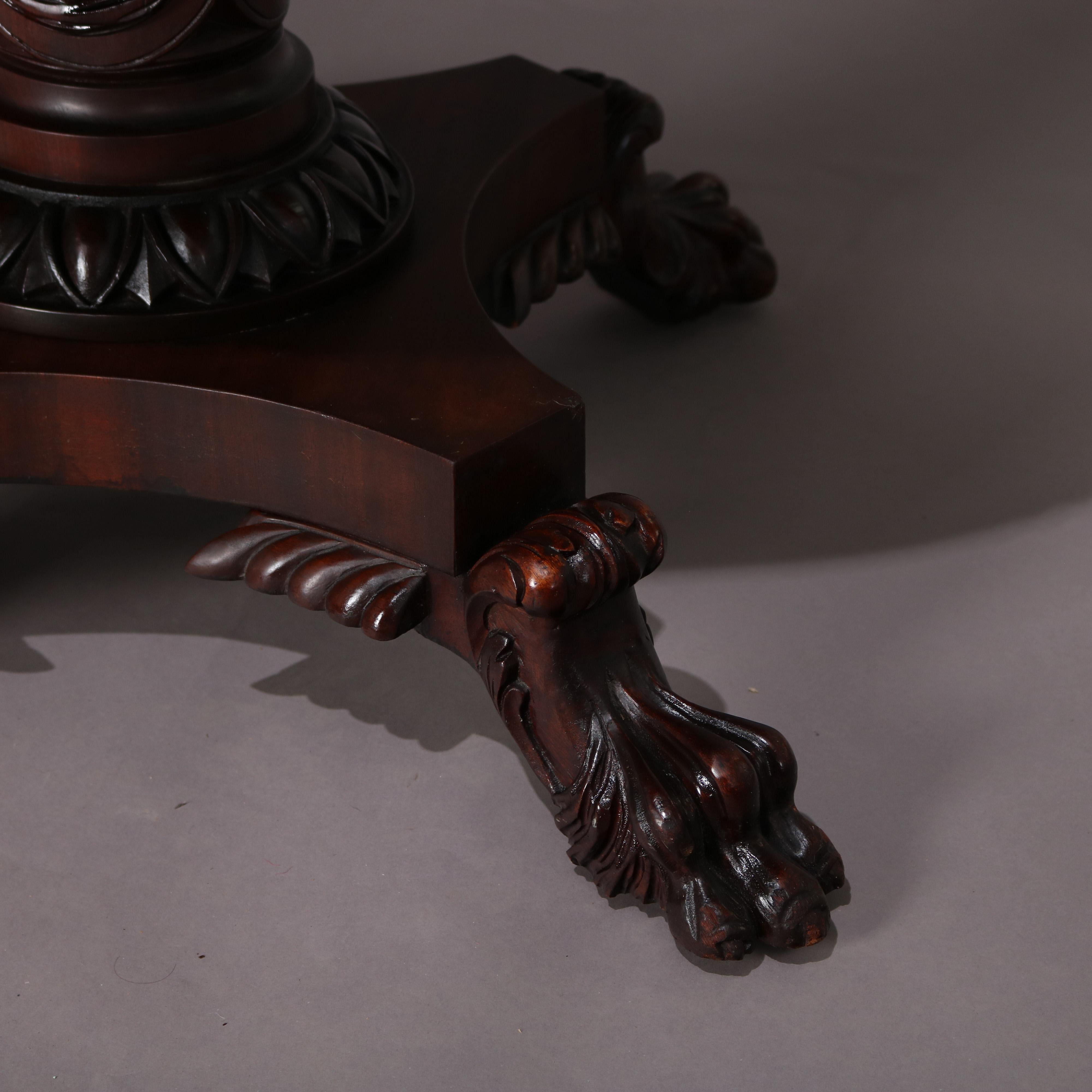 Antique Classical American empire center table features round top with carved twisted rope border surmounting carved acanthus pedestal and raised on carved hairy paw feet, circa 1850.

Measures: 29.5