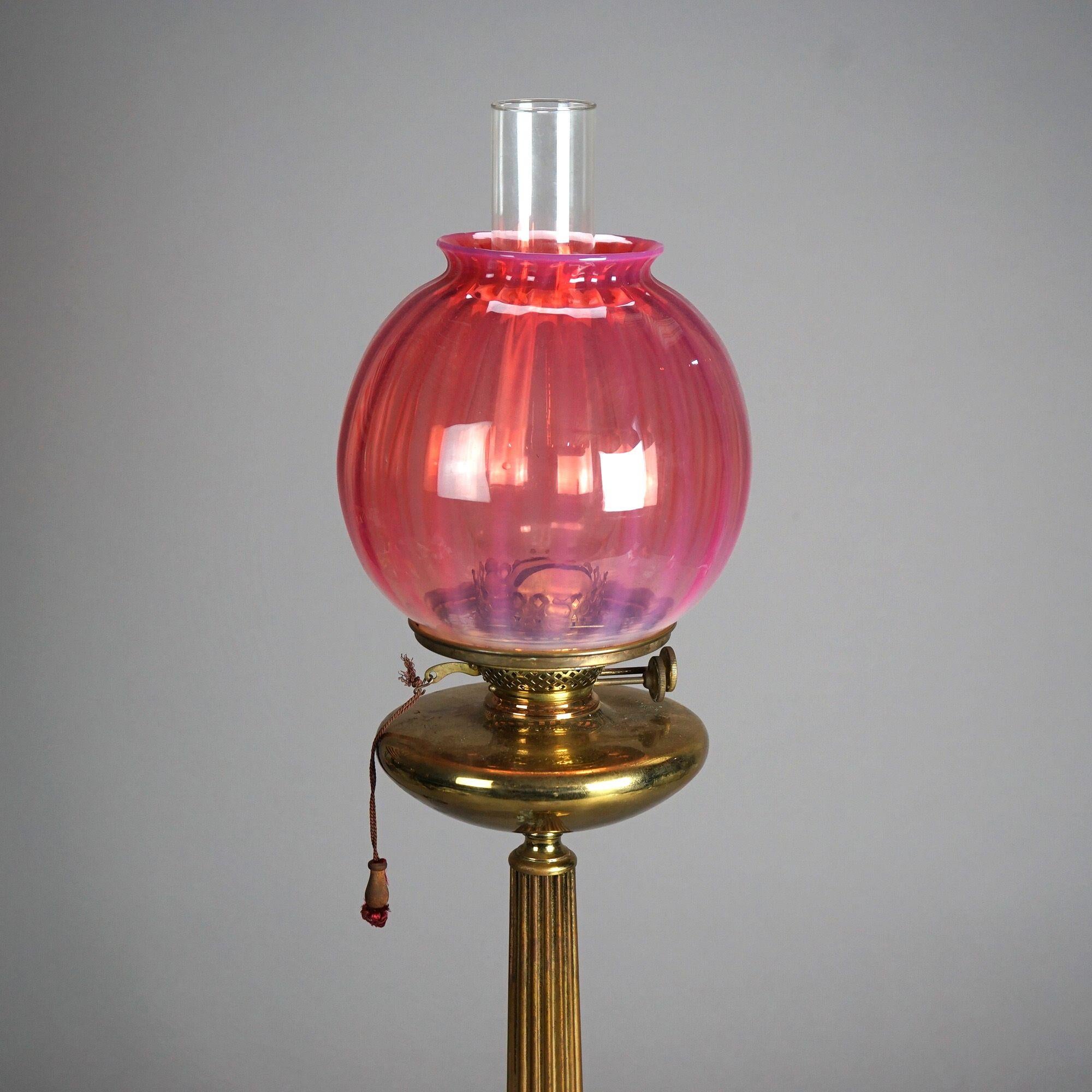 An antique Classical parlor lamp offers cranberry ribbed glass globe shade over cast brass base having fluted column and ball feet, c1880

Measures - 30.5