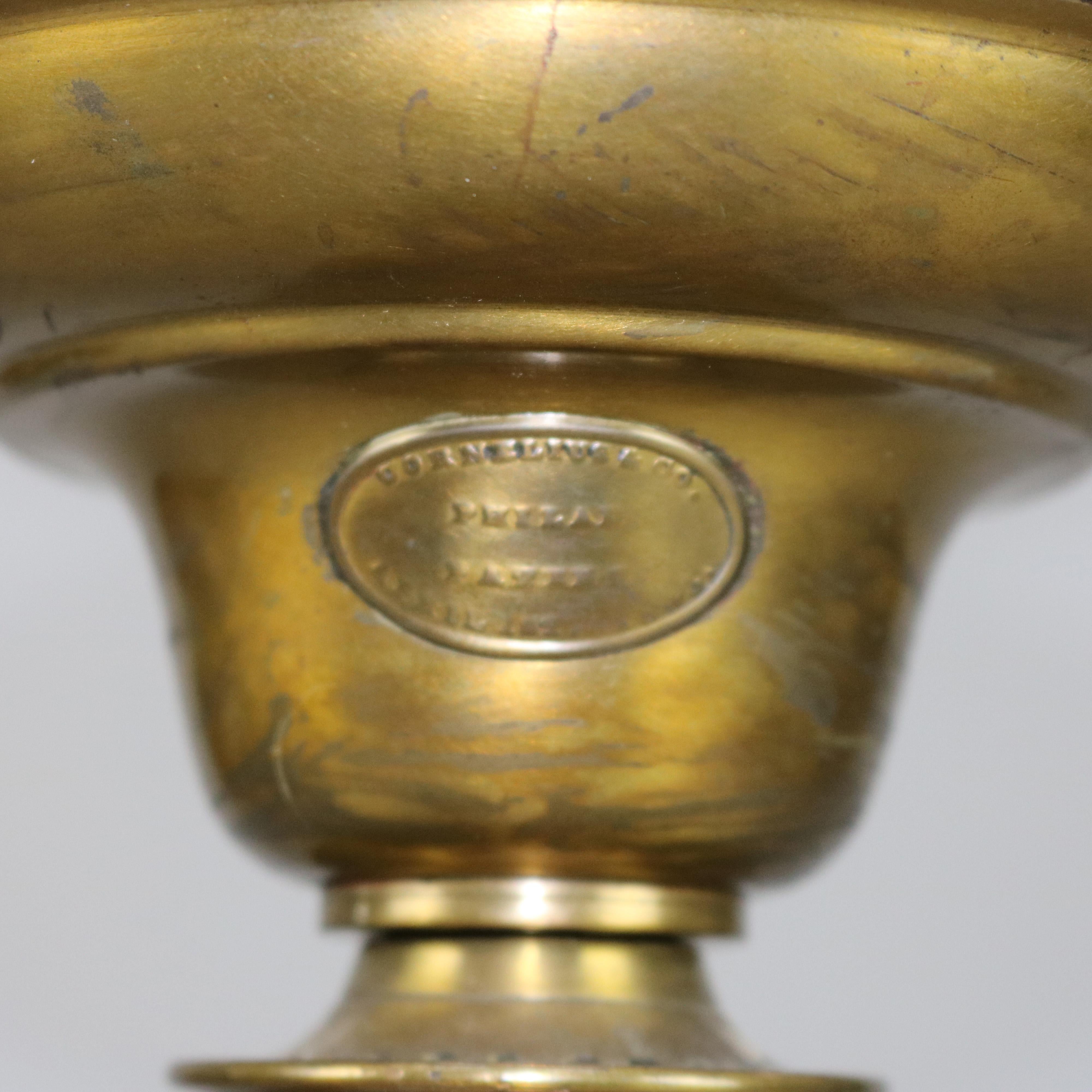 An antique Classical solar oil lamp by Cornelius & Co. offers font with maker label surmounting reeded column and square base, ruffled rim frosted shade with etched decoration, electrified, circa 1890.

Measures: 23