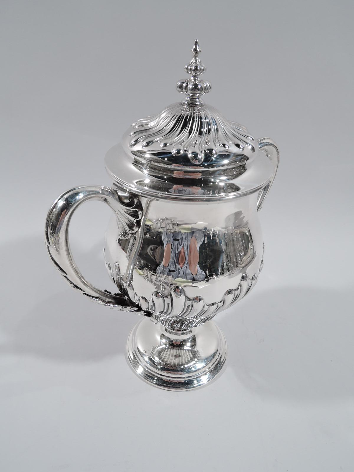 Classical sterling silver covered urn. Made by Howard in New York in 1896. Baluster with leaf-mounted and -covered looping scroll handles, and raised and stepped foot. Cover domed with ornamental finial. Twisted and alternating flutes and gadroons